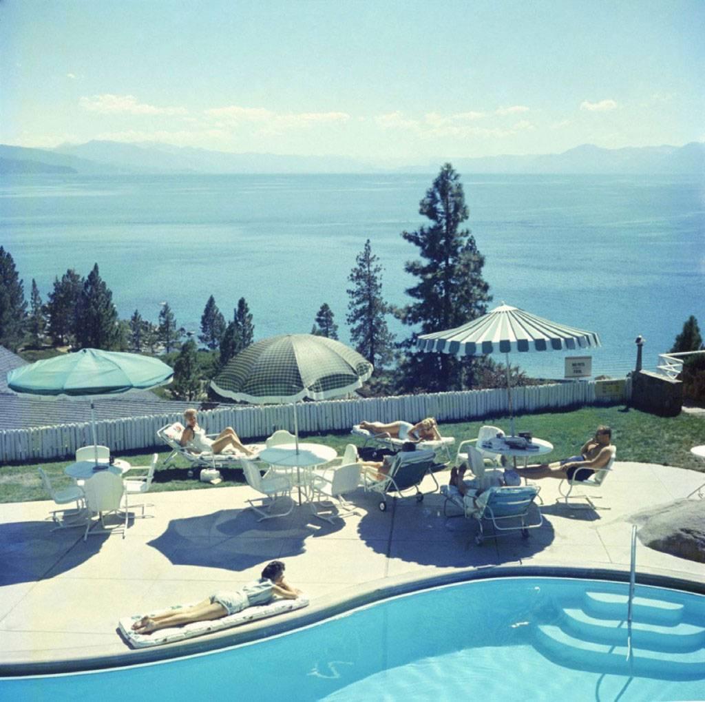 Slim Aarons
Relaxing at Lake Tahoe
1959
Archival pigment print
Estate stamped and hand numbered edition of 150 with certificate of authenticity from the estate.

A group of people relaxing by a pool near Lake Tahoe, California, 1959. 

Slim Aarons