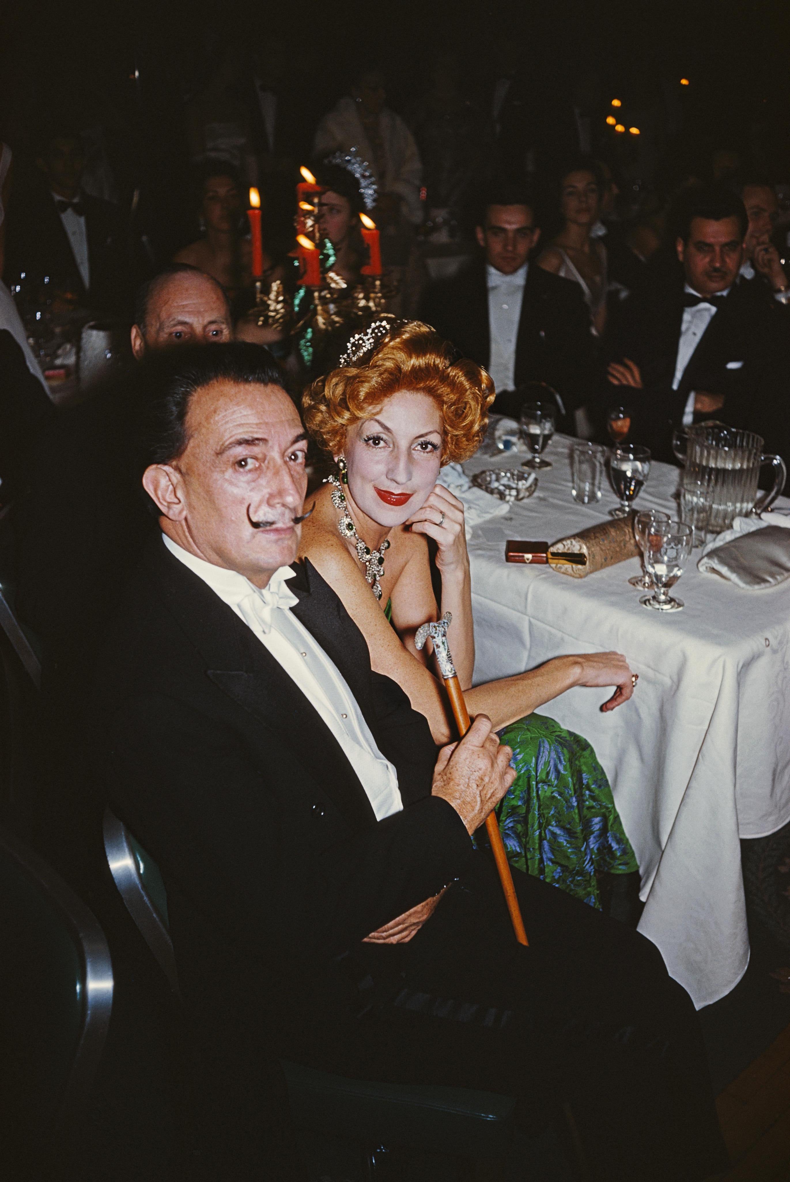 vers 1959 : Le peintre surréaliste Salvador Dali (1904 - 1989) avec une femme aux cheveux roux lors d'un bal à New York. Un temps merveilleux - Slim Aarons

Slim Aarons
La fête de Dali
1959. (imprimé ultérieurement)
C imprimé 
Édition de 150