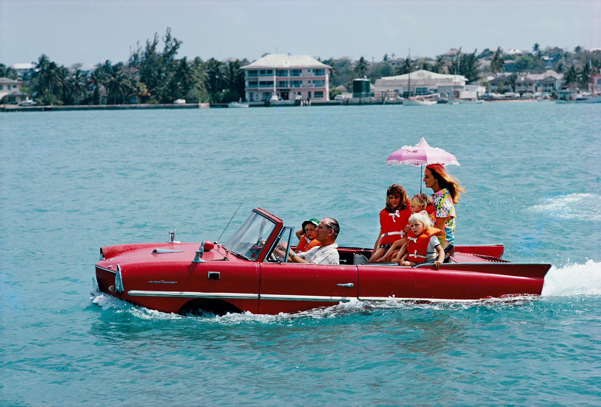 Slim Aarons
Sea Drive, 1967
C-Print
Estate signature stamped and hand numbered edition of 150 with certificate of authenticity from the Slim Aarons estate

Film producer Kevin McClory takes his wife Bobo Sigrist and their family for a drive in an