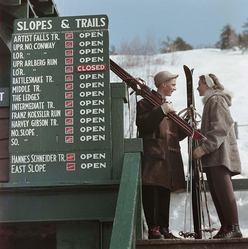 Two skiers talking next to an information sign showing nearby ski slopes and trails, Cranmore Mountain, North Conway, New Hampshire, 1955. 

Slim Aarons
Slopes & Trails
Chromogenic Lambda print
Slim Aarons Estate Edition
Complimentary dealer