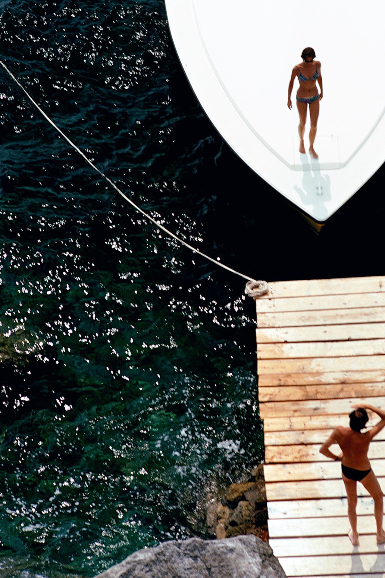 Speedboat Landing, Porto Ercole, Estate Edition - Black Figurative Photograph by Slim Aarons