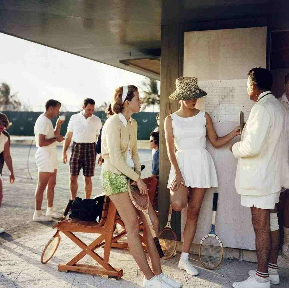 Tennis in the Bahamas, 1957
Chromogenic lambda print 
Estate stamped and hand numbered edition of 150 with certificate of authenticity from the estate.    

Two women stand talking to a man on the edge of a tennis court in the Bahamas, circa 1957.