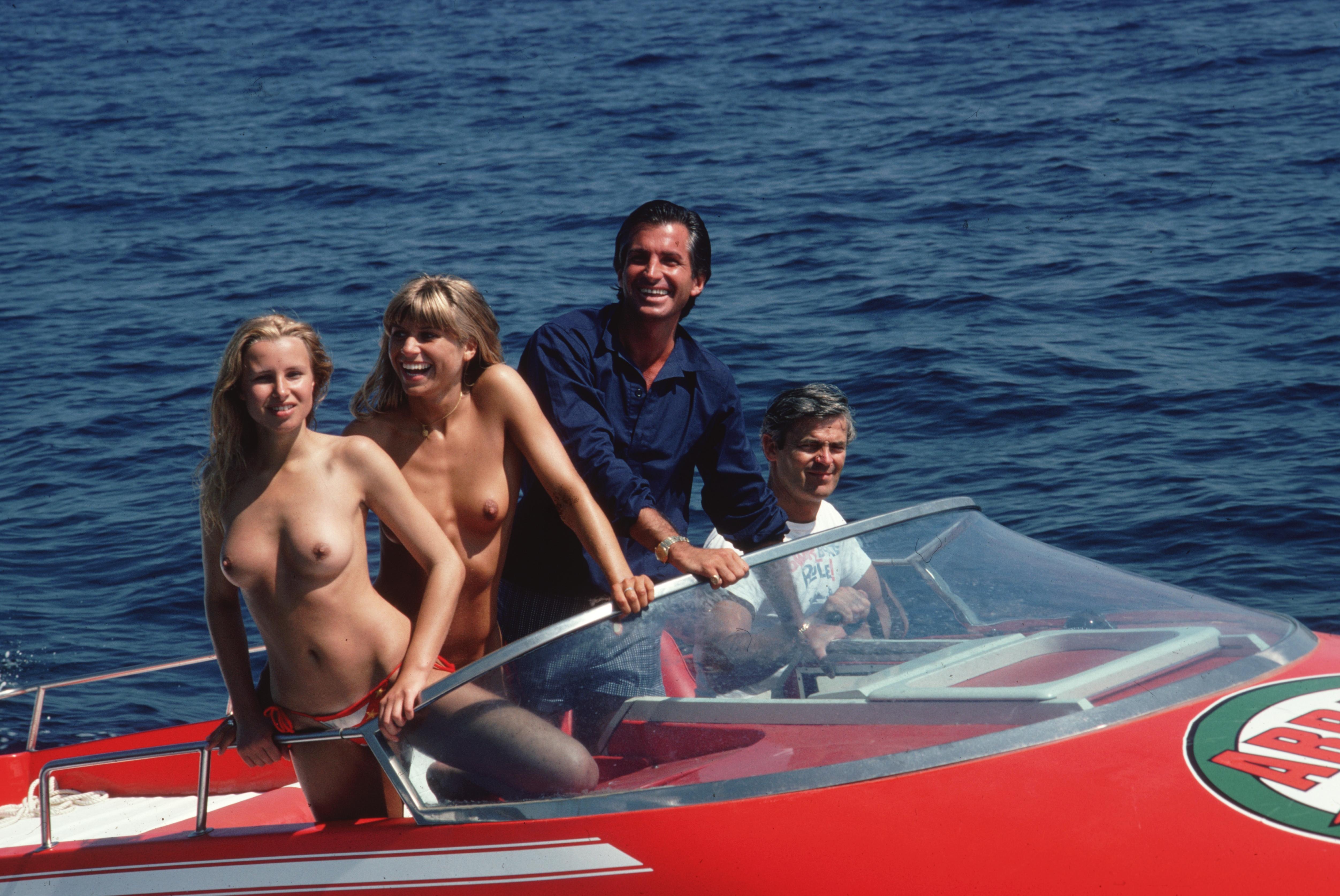 Slim Aarons
The High Life
1977. (printed later)
C print 
Estate stamped and numbered edition of 150 
with Certificate of authenticity

August 1977: Actor George Hamilton (in blue) takes off in a speedboat with friends Ruth Luthi and Mike Belami,