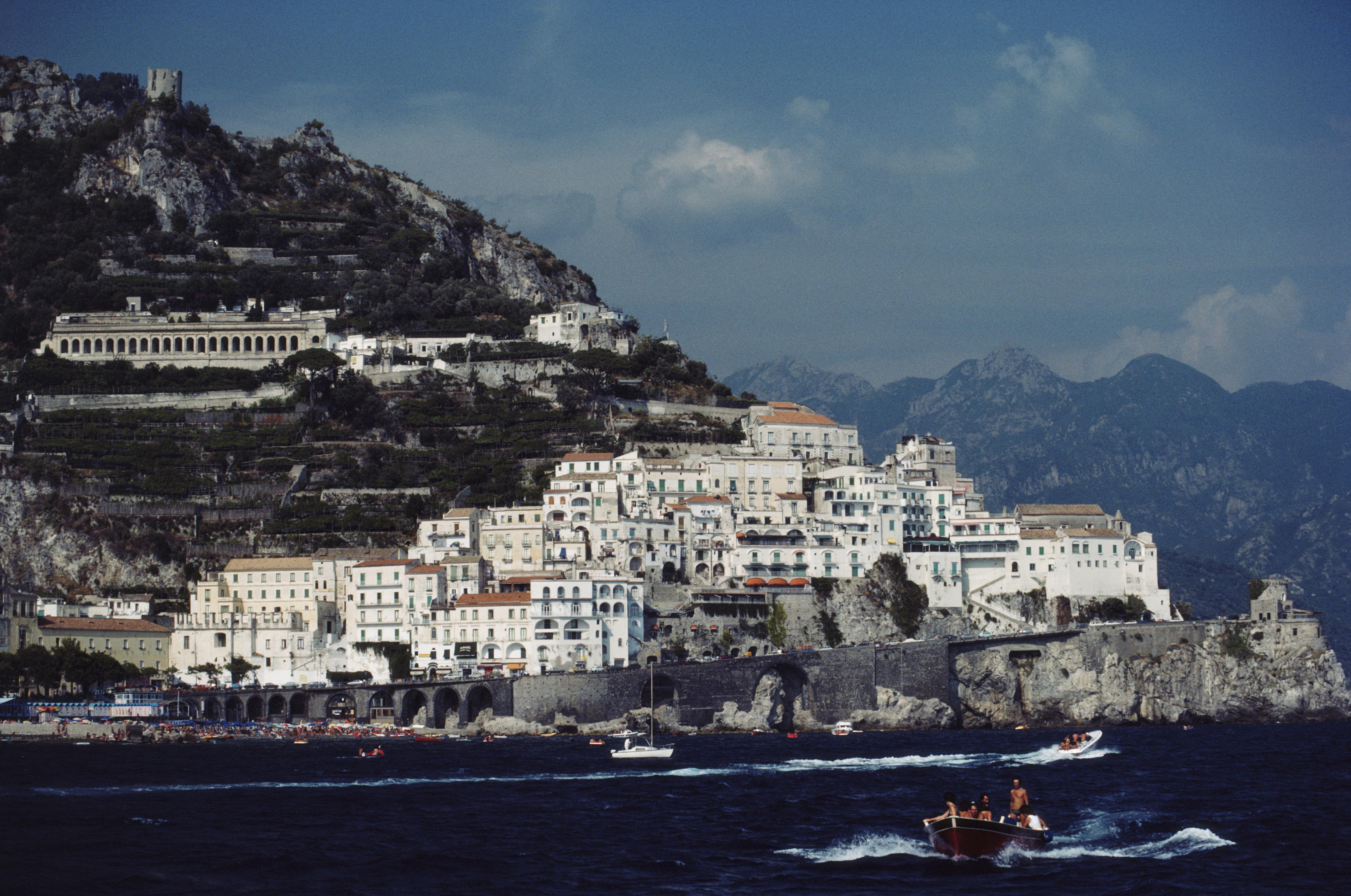 Schlanke Aarons
Die Townes von Amalfi
1984
C Druck
Nachlassgestempelte und handnummerierte Auflage von 150 Stück mit Echtheitszertifikat des Nachlasses.   

Gesamtansicht der Küstenstadt Amalfi auf der sorrentinischen Halbinsel mit Booten entlang