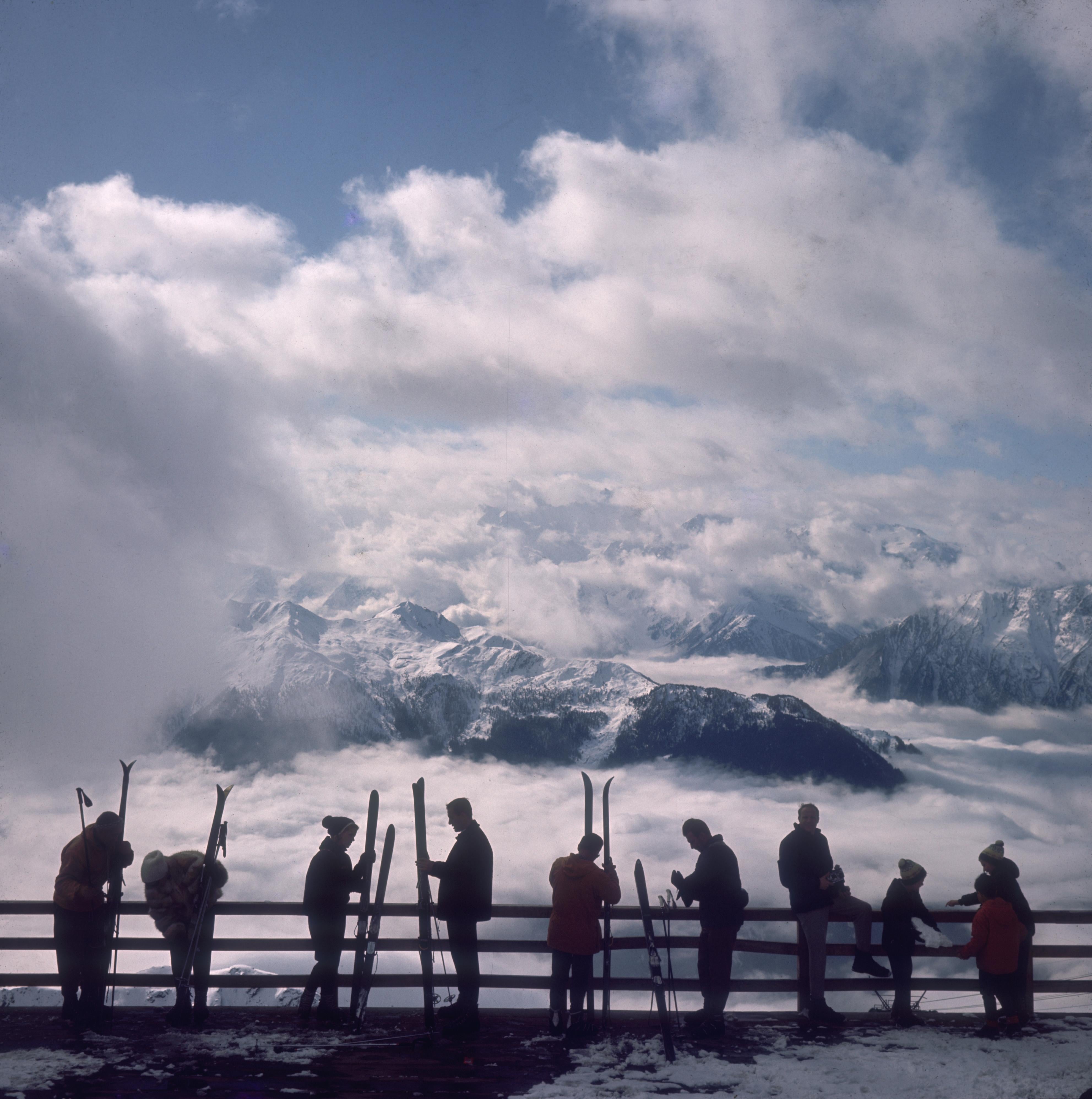 Slim Aarons
Verbier View, 1964. (printed later)
Archival pigment print
60 x 60 inches
Estate stamped and numbered edition of 150 
with Certificate of authenticity

Skiers admire the view across a valley of clouds at Verbier, 1964.

Slim Aarons