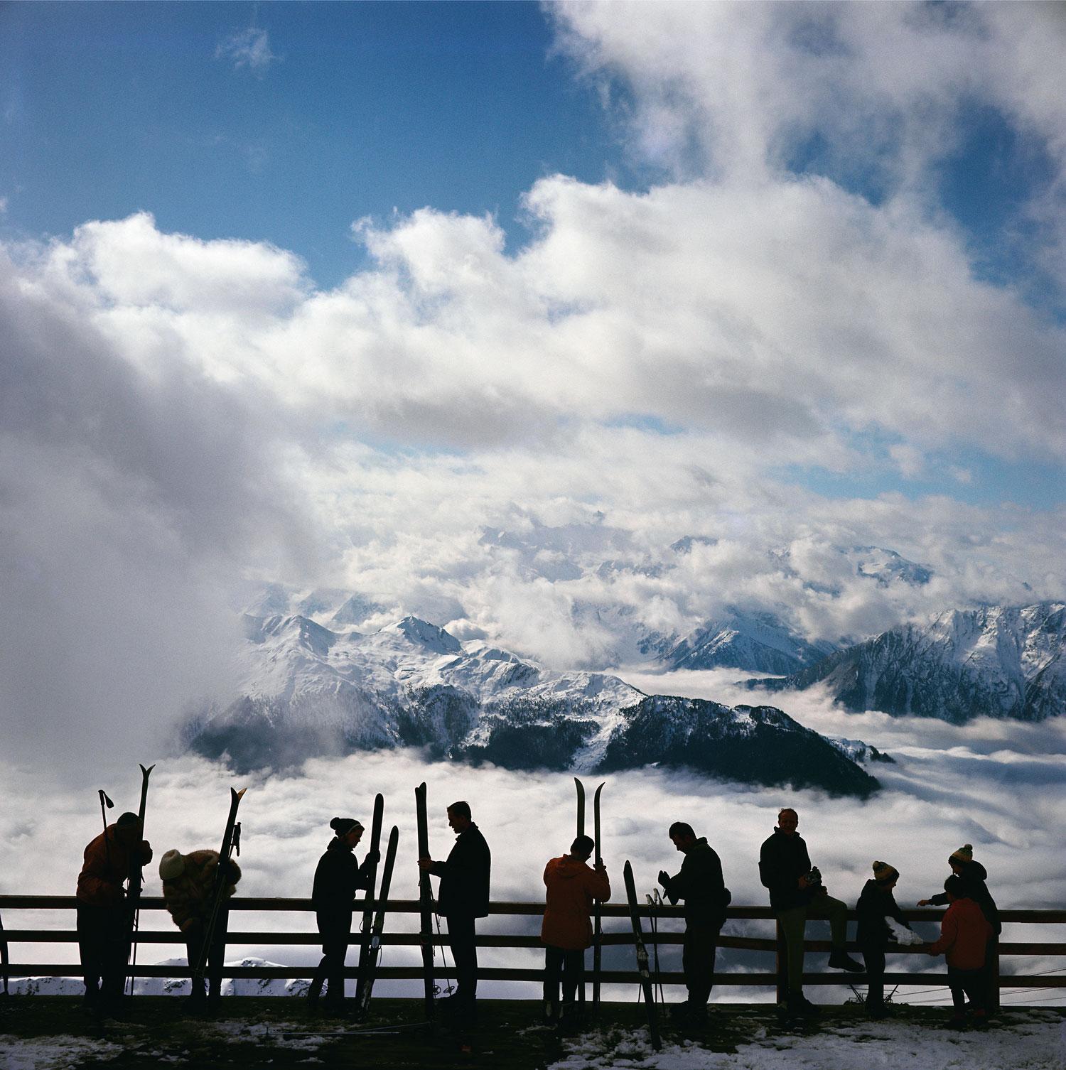Klosters
1963
C-Print
Estate signature stamped and hand numbered edition of 150 with certificate of authenticity from the estate.   

Skiers admire the view across a valley of clouds at Verbier, 1964. (Photo by Slim Aarons/Hulton Archive/Getty