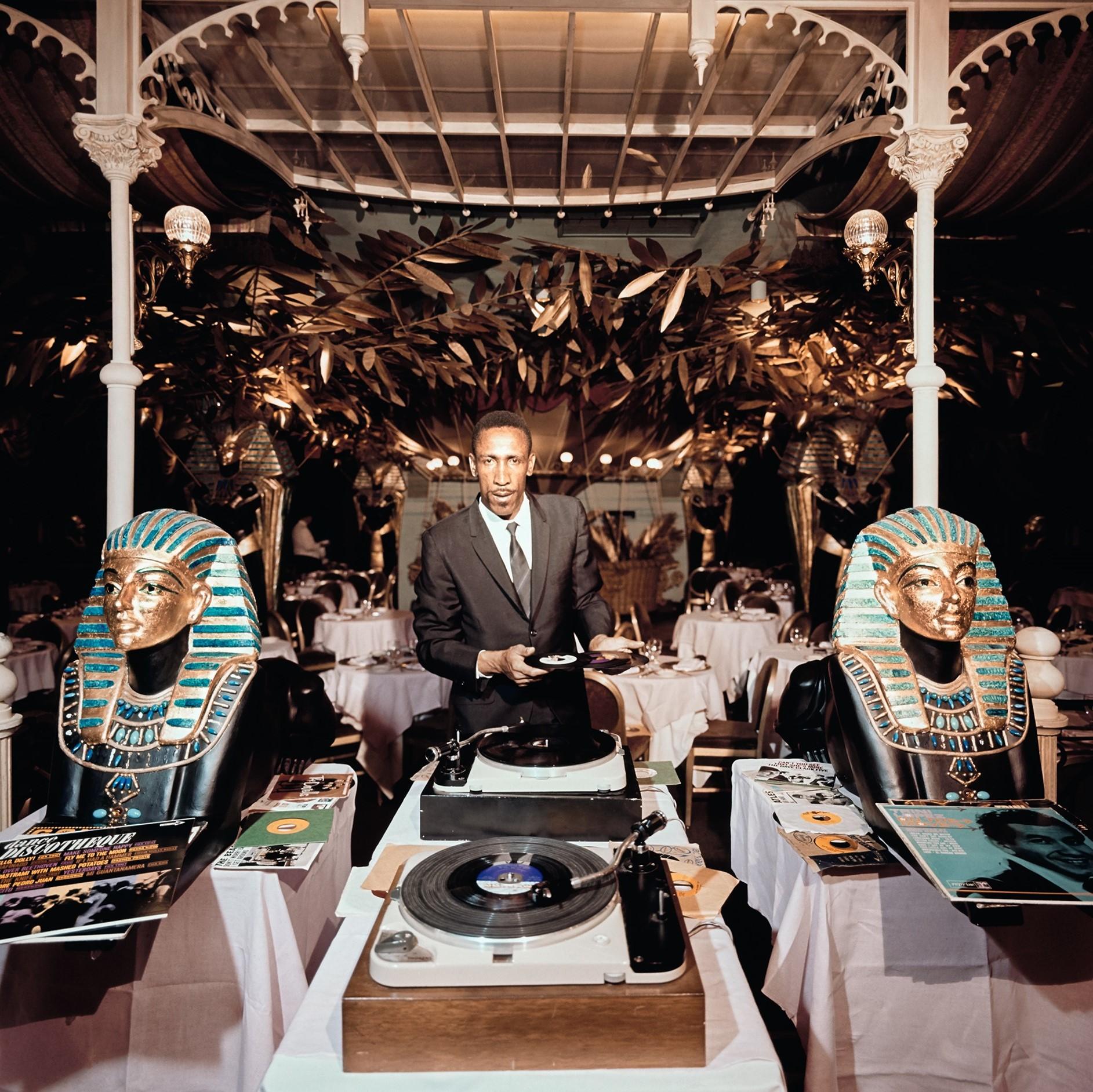 Slim Aarons Portrait Photograph - Slim and Sphinx - Musician Poses with Egyptian Sphinx under Gold Laurel Leaves