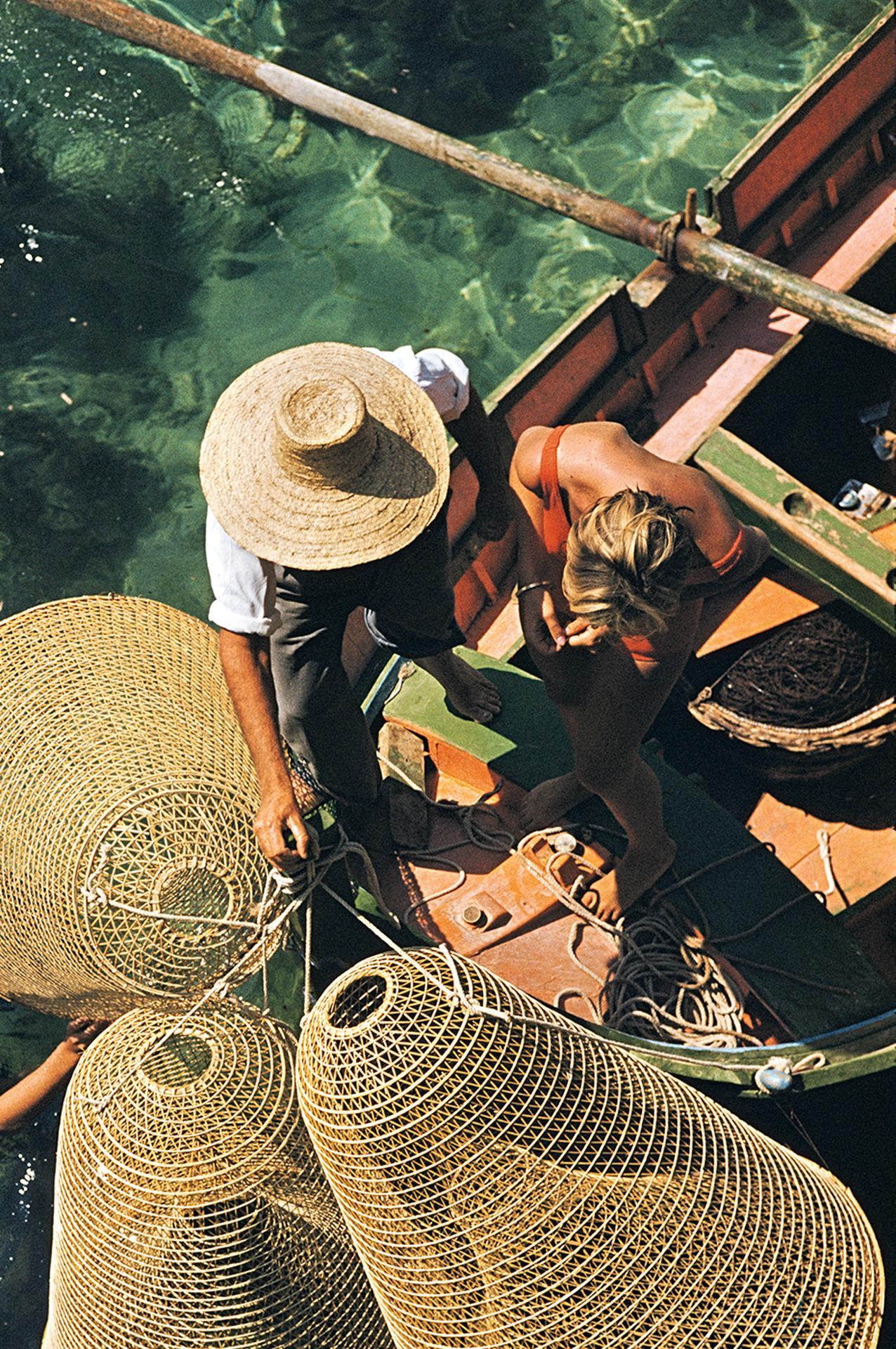 Cette photographie de paysage aérien datant de la fin des années 1950, prise par le photographe mondain Slim Aarons, montre un groupe de personnes faisant de la plongée en apnée à partir d'un petit bateau à Malte.

Il s'agit d'une édition de 150
