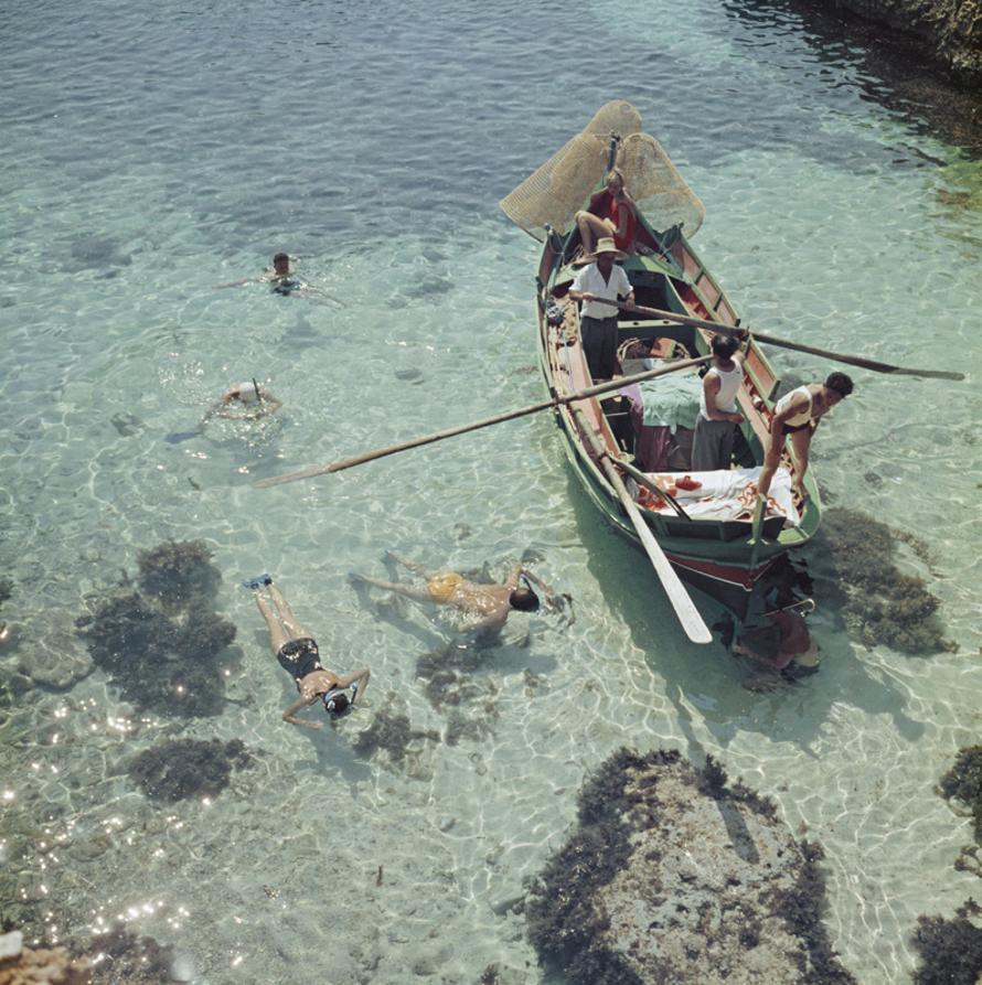 Snorkelling In The Shallows 
1959
by Slim Aarons

Slim Aarons Limited Estate Edition

A group of people snorkelling off a small boat in Malta, circa 1959. 

unframed
c type print
printed 2023
16 × 16 inches - paper size


Limited to 150 prints only