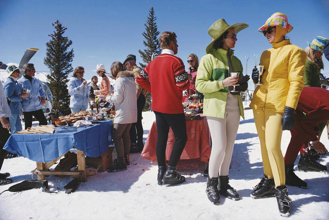 Zwei Frauen in farbenfroher Skikleidung stehen im Vordergrund einer Gruppe von Besuchern einer Party in Snowmass Village in Pitkin County, Colorado, im April 1968 (Foto von Slim Aarons/Getty Images)

Dieses Foto stammt aus der auf 150 Exemplare