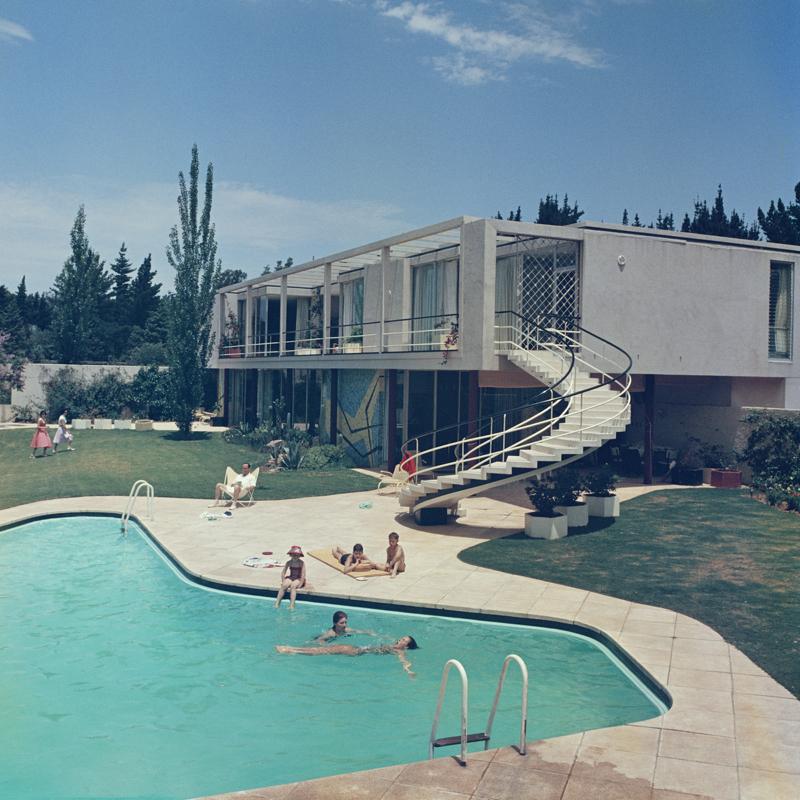 South Africa Swimming Pool 
1958
by Slim Aarons

Slim Aarons Limited Estate Edition

A luxury house in South Africa with stairs leading to the swimming pool in the garden, 1958.

unframed
c type print
printed 2023
16 × 16 inches - paper