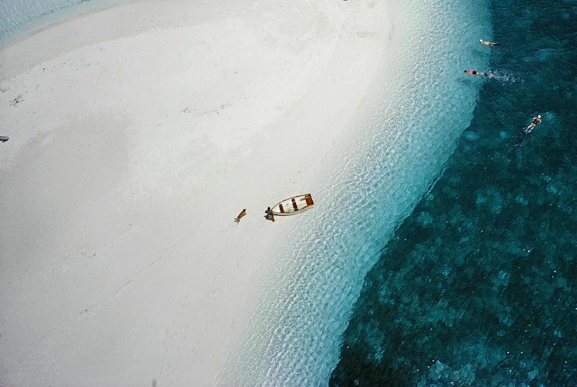 Esta fotografía aérea del paisaje marino de mediados de la década de 1960, captada por el fotógrafo de sociedad Slim Aarons, muestra una vista desde un ángulo alto de personas nadando junto al ketch 