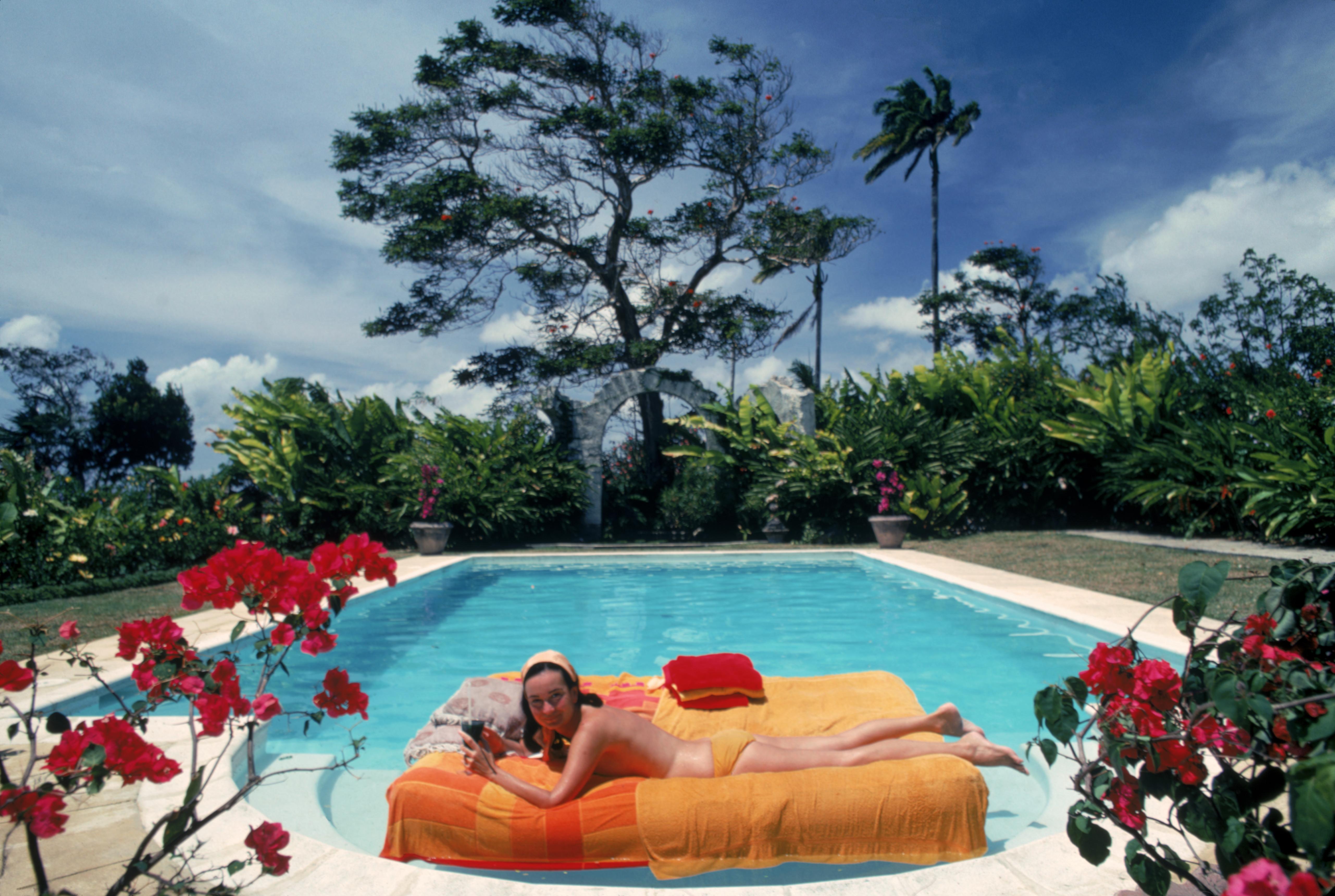 'Sunbathing In Barbados' 1976 Slim Aarons Limited Estate Edition Print 

The former Pauline Haywood sunbathing on a lilo in a swimming pool designed by English artist Oliver Messel, Barbados, April 1976. Her family owned Haywood's Plantation.