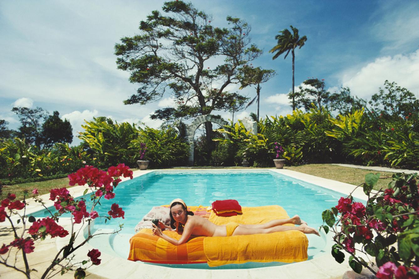 Sunbathing In Barbados 
1976
by Slim Aarons

Slim Aarons Limited Estate Edition

The former Pauline Haywood sunbathing on a lilo in a swimming pool designed by English artist Oliver Messel, Barbados, April 1976. Her family owned Haywood’s
