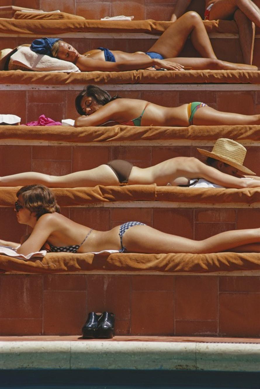 Sunbathing In Capri 
1974
by Slim Aarons

Slim Aarons Limited Estate Edition

Sunbathers by a swimming pool in Capri, Italy, August 1974.

unframed
c type print
printed 2023
20 × 16 inches - paper size


Limited to 150 prints only – regardless of