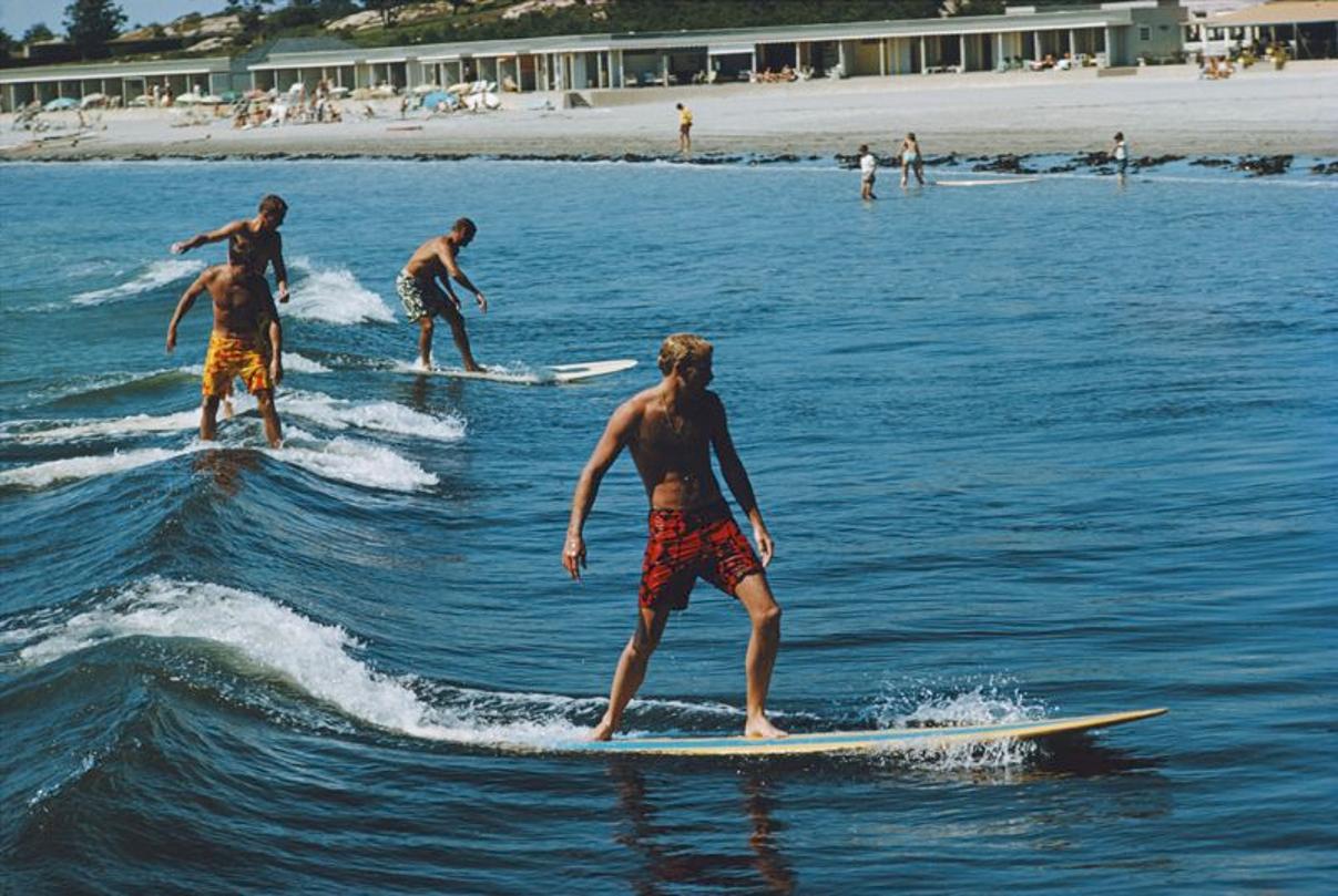 Surfing Brothers 
1980
by Slim Aarons

Slim Aarons Limited Estate Edition

Freddie and Howard Cushing surfing with friends at Bailey’s Beach (the Spouting Rock Beach Association) in Newport. Their father introduced the sport to the club in the