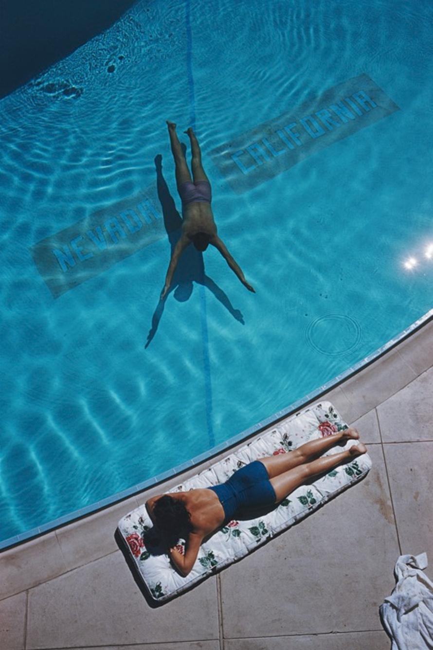 Swimmer And Sunbather 
1959
by Slim Aarons

Slim Aarons Limited Estate Edition

An underwater swimmer and a sunbather at Lake Tahoe, 1959. The line on the bottom of the pool marks the state line between Nevada and California.

unframed
c type