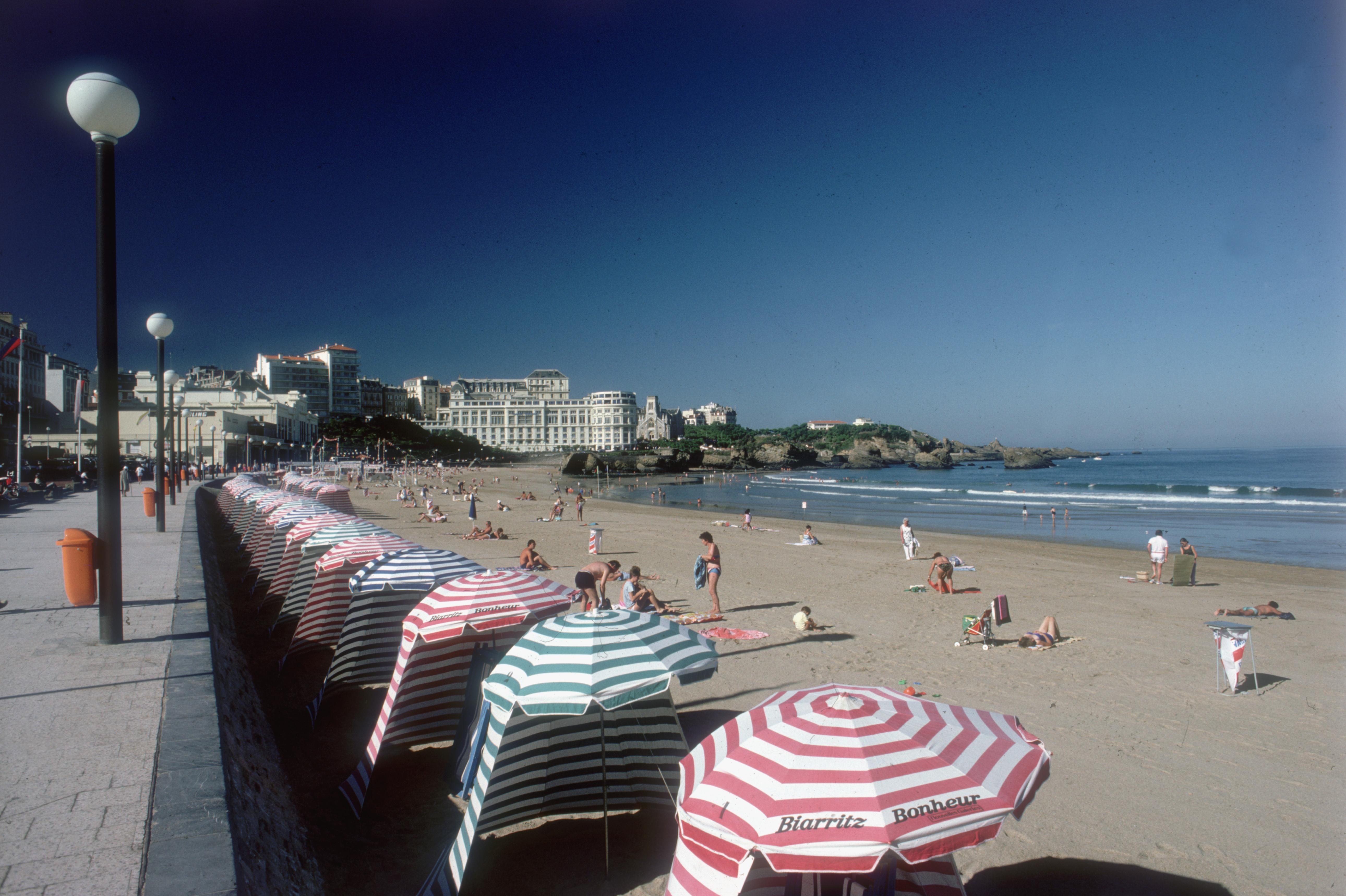 'The Grand Plage' 1985 Slim Aarons Limited Estate Edition Print 

1985, The Grand Plage, Biarritz, dominated by the Bellevue Casino and the Hotel du Palais, and the Bay of Biscay beyond. 

Produced from the original transparency
Certificate of