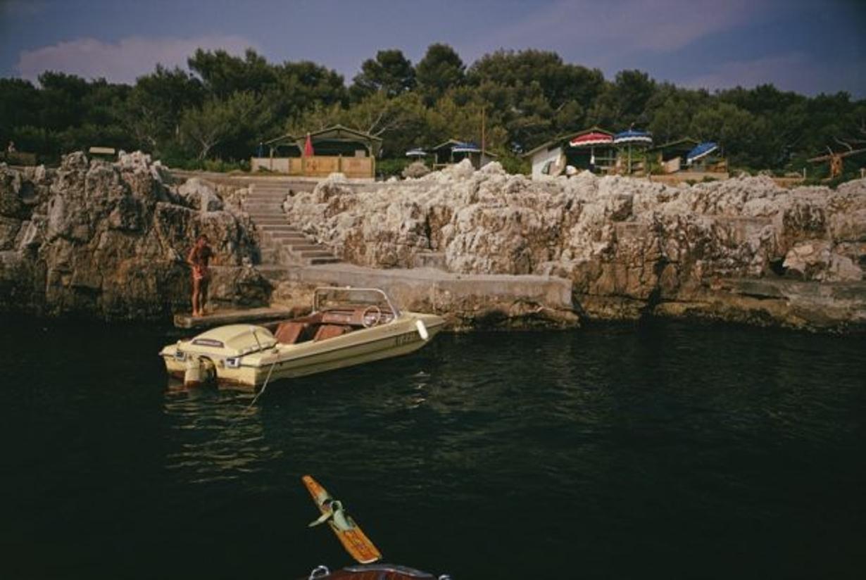 Towboat At Hotel Du Cap-Eden-Roc 
1969
by Slim Aarons

Slim Aarons Limited Estate Edition

A motorboat, used to tow waterskiiers, moored at the Hotel du Cap-Eden-Roc in Antibes on the French Riviera, August 1969

unframed
c type print
printed