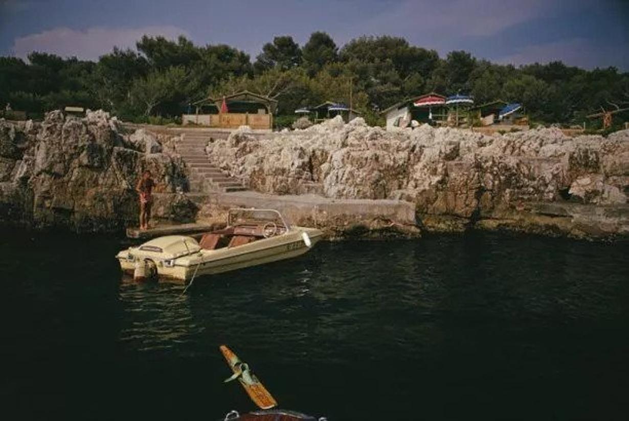 Towboat At Hotel Du Cap-Eden-Roc 
1969
by Slim Aarons

Slim Aarons Limited Estate Edition

A motorboat, used to tow waterskiiers, moored at the Hotel du Cap-Eden-Roc in Antibes on the French Riviera, August 1969. 

unframed
c type print
printed