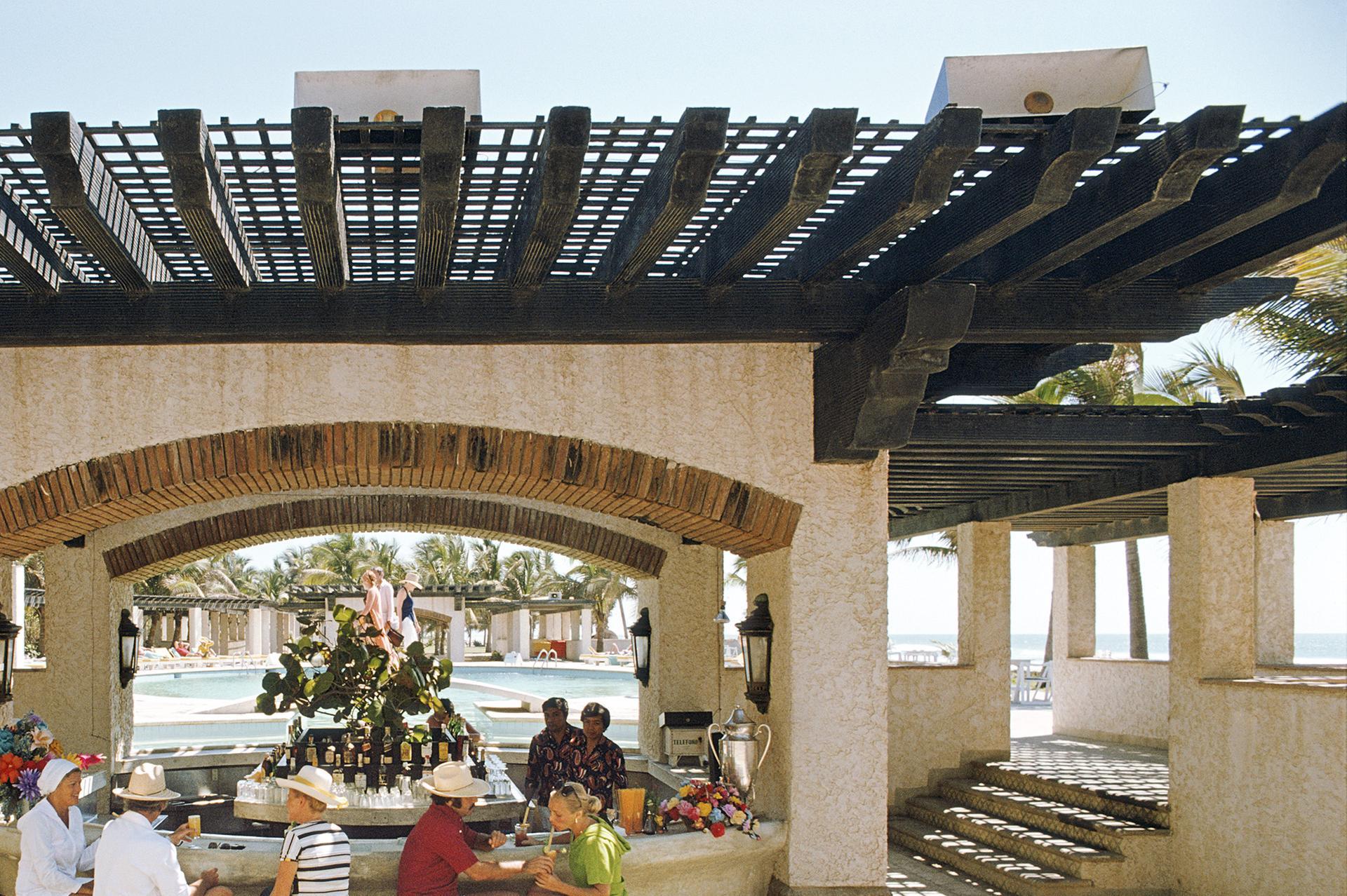 Des clients se détendent à l'ombre au club privé Tres Vidas, Acapulco, Mexique, février 1975.

Expédition gratuite du revendeur à votre encadreur, dans le monde entier.

Undercurrent Projects est fier d'offrir cette vibrante photographie, imprimée