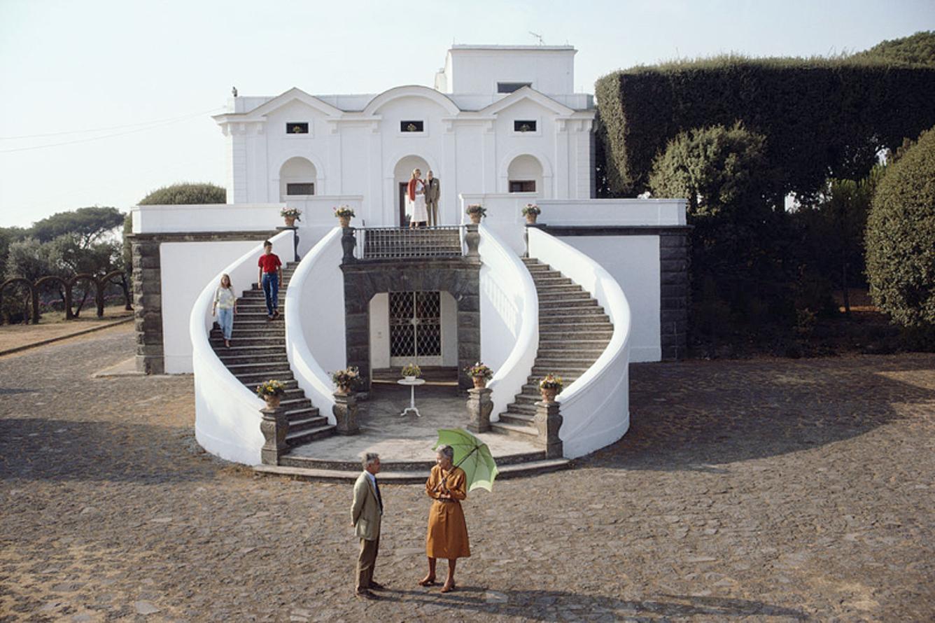 Villa Olivella 
1985
by Slim Aarons

Slim Aarons Limited Estate Edition

The Conte and Contessa Paolo Gaetani dell’Aquila d’Aragona posing before their neoclassical Villa Olivella in Naples, Italy, in October 1985.

unframed
c type print
printed