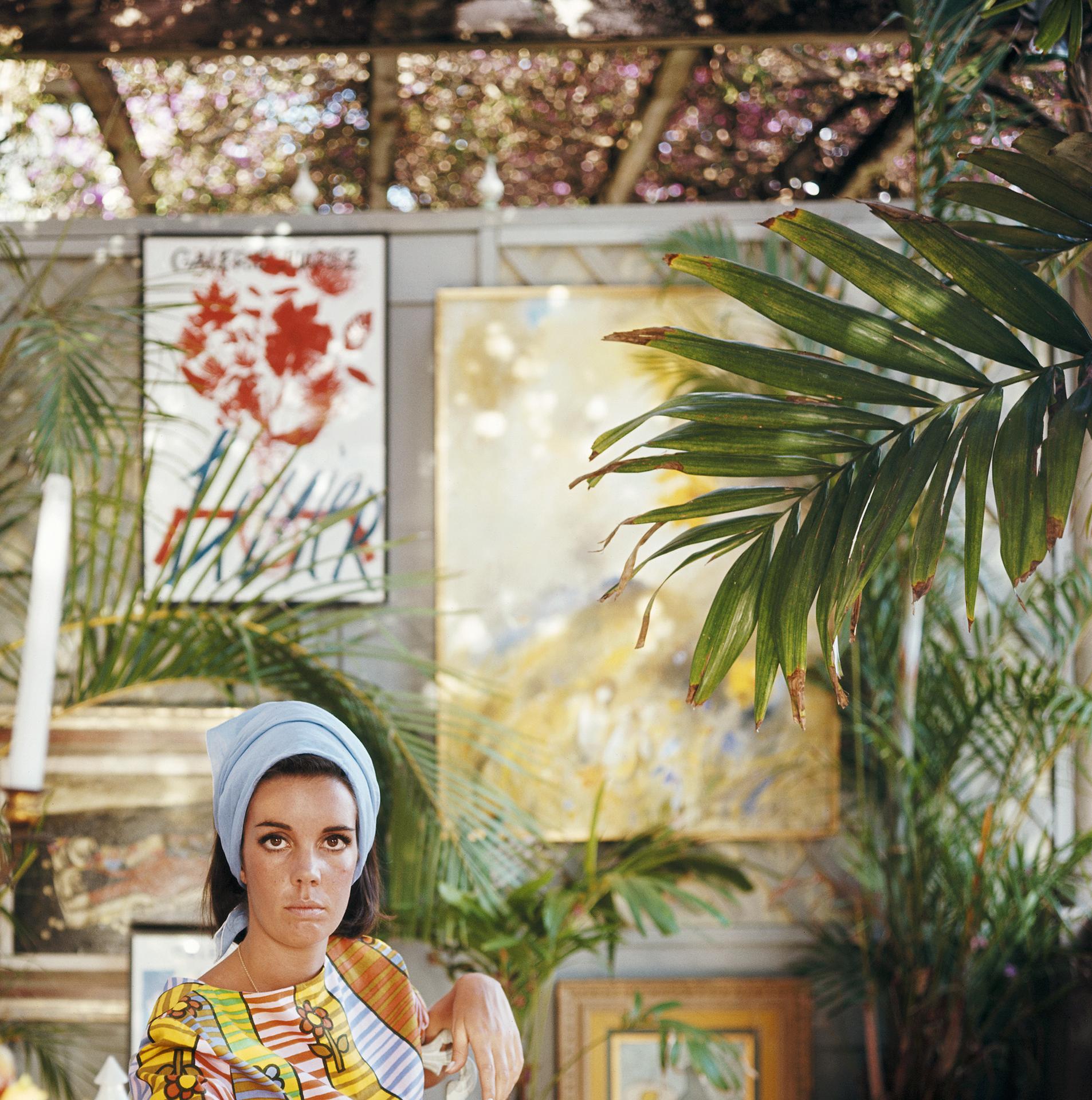 Ce portrait du milieu des années 1960, réalisé par le photographe mondain Slim Aarons, montre la mondaine américaine Wendy Vanderbilt chez elle à Palm Beach, en Floride, aux États-Unis.
Il s'agit d'une édition de 150 exemplaires estampillés et