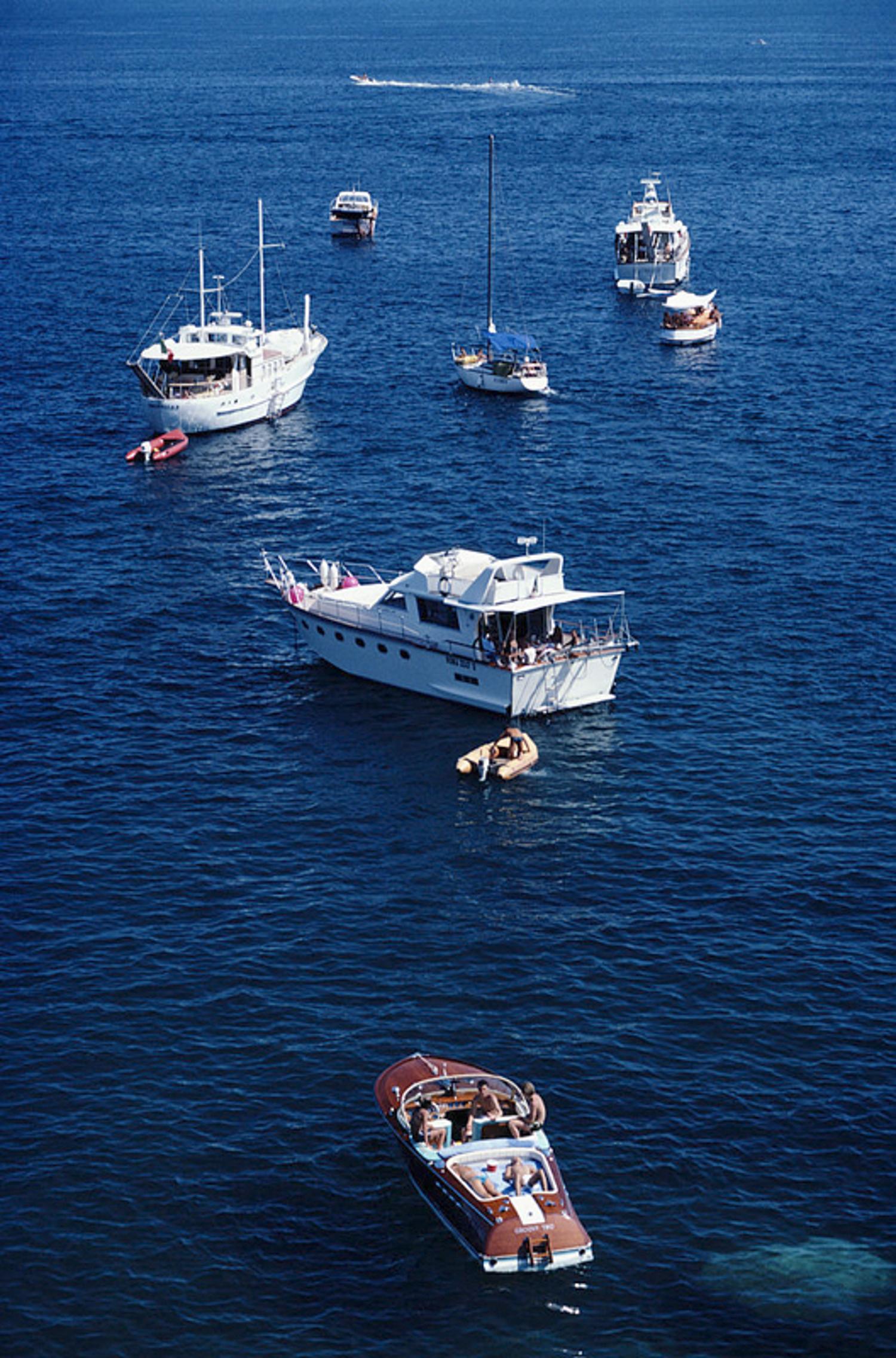 Yachting Holiday 
1980
by Slim Aarons

Slim Aarons Limited Estate Edition

A small flotilla of pleasure crafts moored in the sea off Italy, August 1980.

unframed
c type print
printed 2023
24 x 20"  - paper size

Limited to 150 prints only –