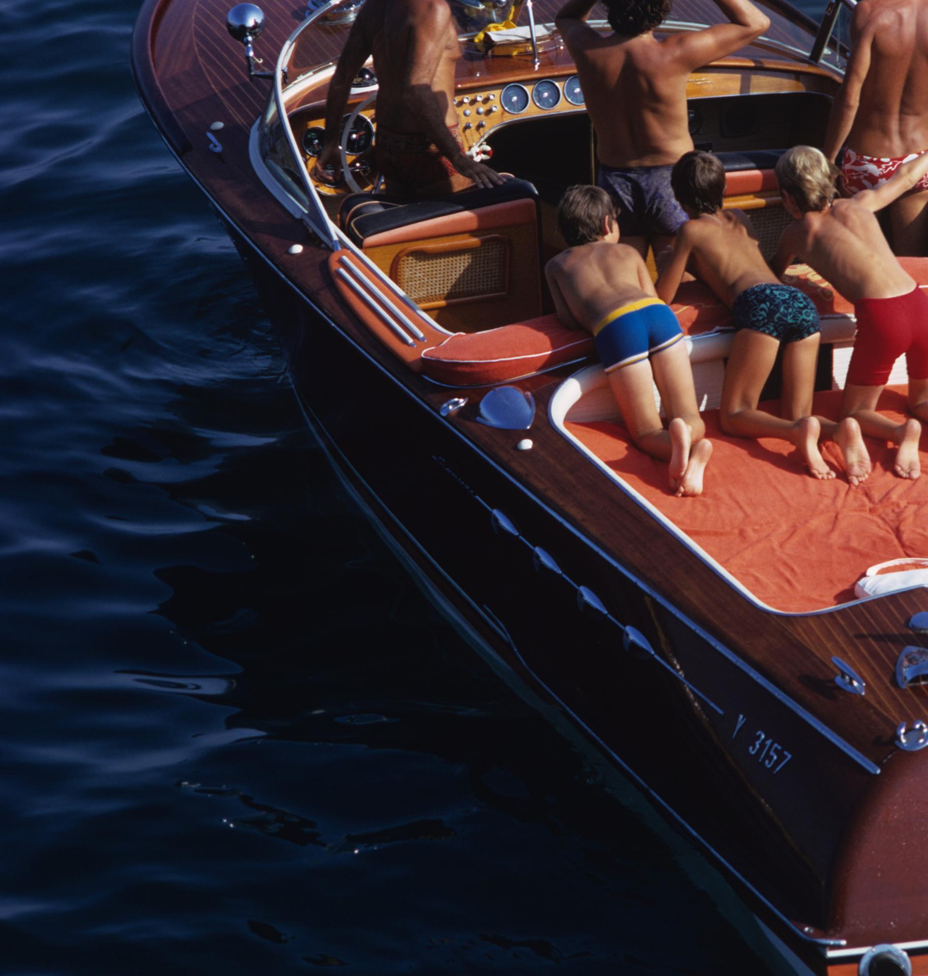 Monte Carlo, 1970: This classic landscape photograph, captured by society photographer Slim Aarons, features a vintage wooden and red painted speedboat carrying  holidaygoers in the deep blue Mediterranean waters of Monte Carlo, Monaco in
