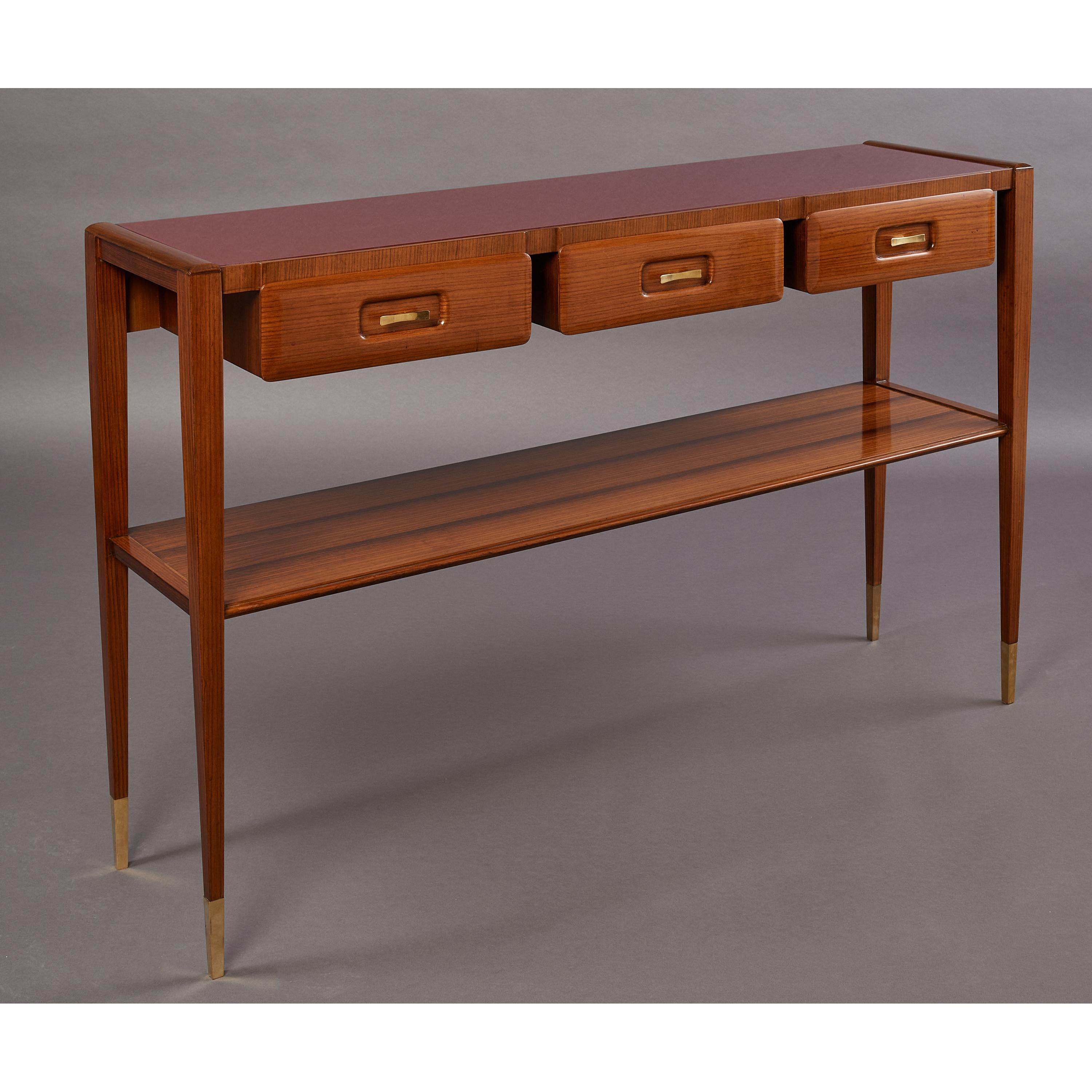 ITALY 1950's, in the manner of Gio Ponti
A slim, elegantly proportioned console table with beautifully grained light woods, three drawers with carved insets and sculpted brass handles, one elegantly veneered lower shelf, tapered legs ending in