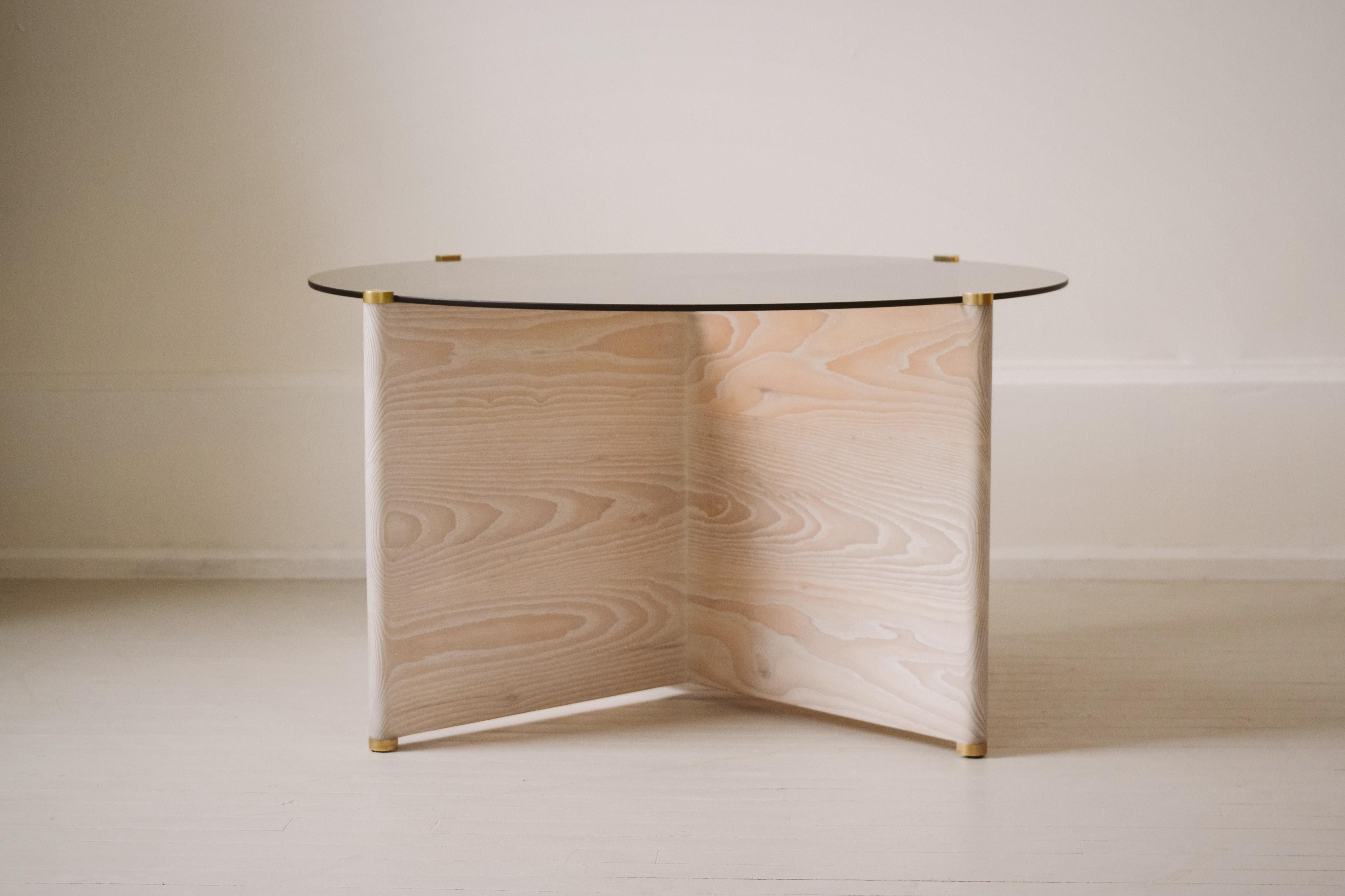 Slim Table ist ein Couchtisch mit einem Gestell aus massivem Eschenholz und Messingdetails, das eine runde Platte aus Rauchglas trägt. Gebleicht und mit einem handgeriebenen Hartwachs-Weißöl behandelt. 