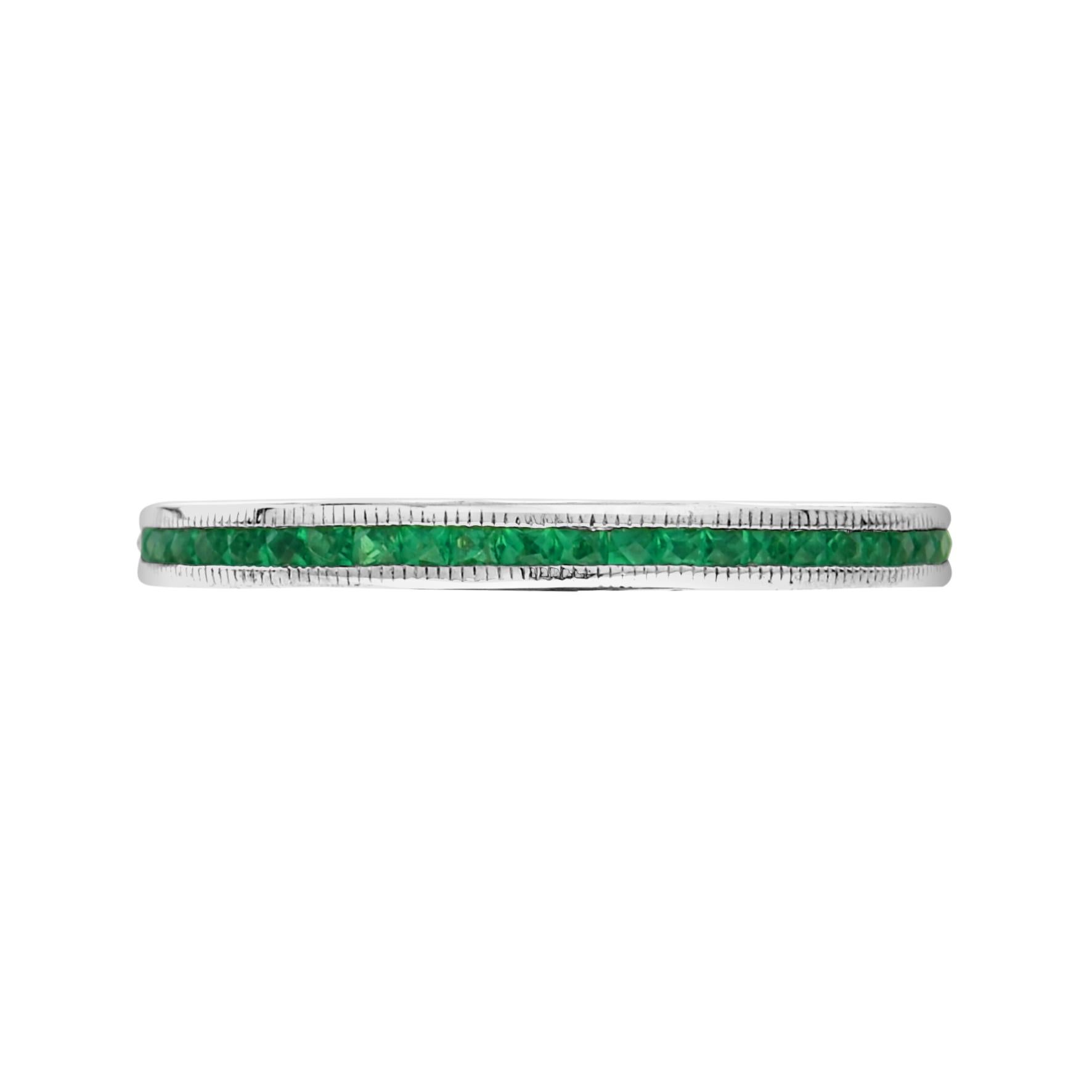 Discover a beautiful and dainty piece of art deco history. The natural French cut emeralds run around the entire ring in an enclosed type of setting. This piece is great for wearing with an antique or vintage engagement ring or stacking with