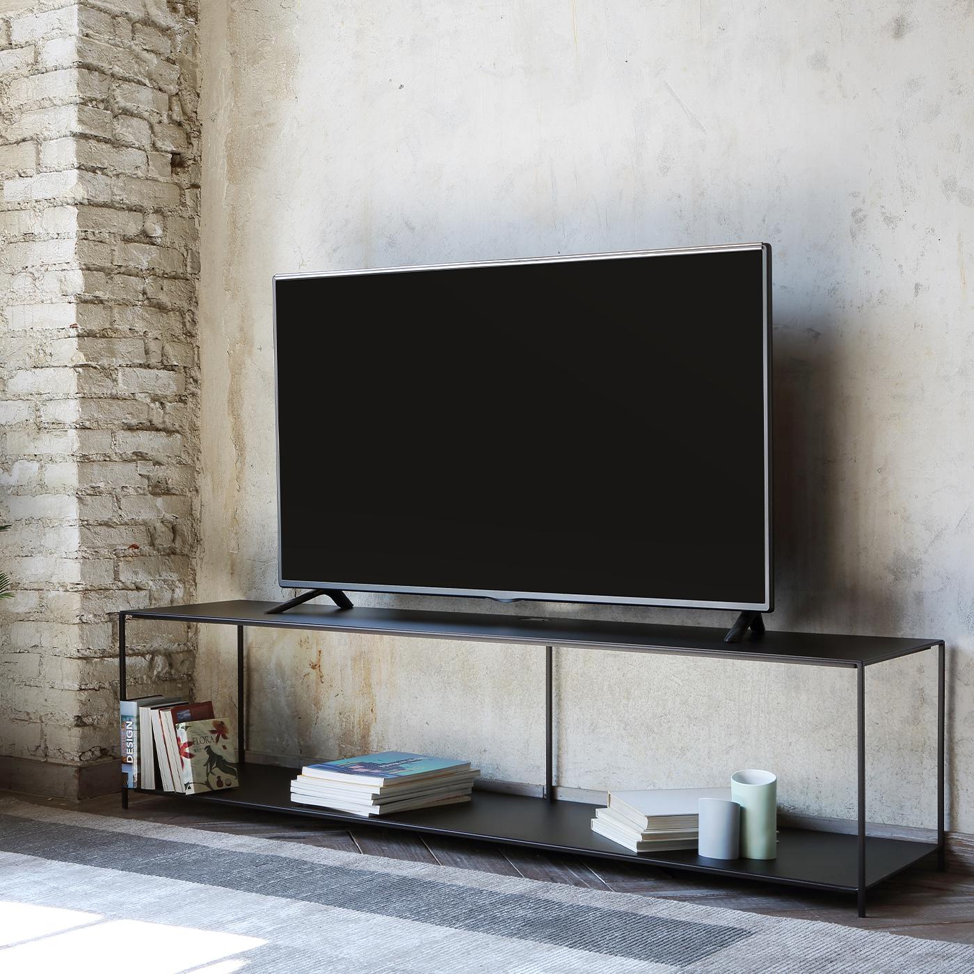 Ode au minimalisme qui s'exprime facilement à travers des lignes épurées et rigoureuses, ce meuble TV en cuivre constitue un complément astucieux et cohérent aux décors contemporains de style essentiel. Cinq minces éléments cylindriques soutiennent