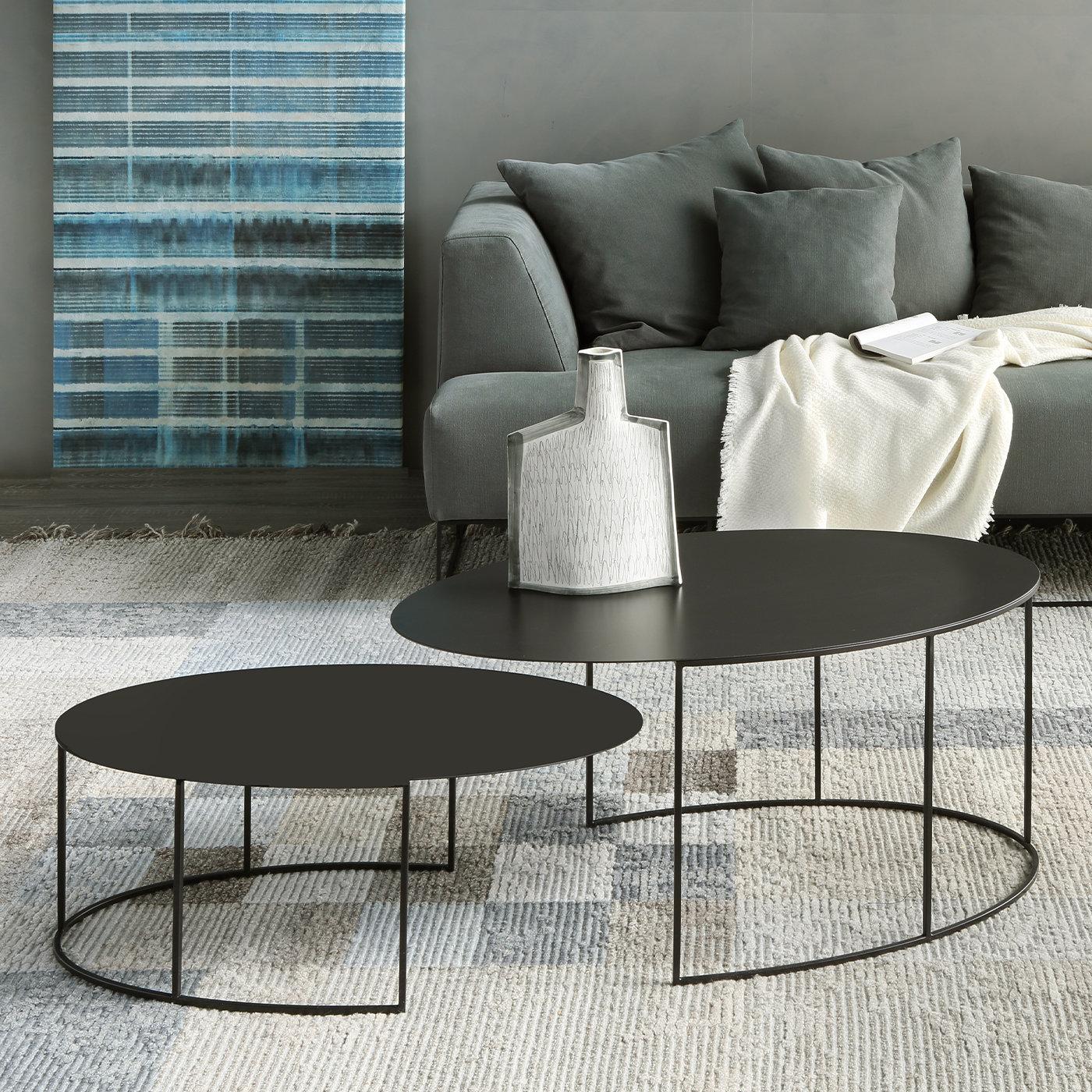 This striking set of two oval tables is designed to create an eye-catching focal point in any interior. Raised on a semicircular open base of steel tubes (8 x 8 mm) in epoxy-painted copper black with sand-texture effect, the slim oval tops (2 mm