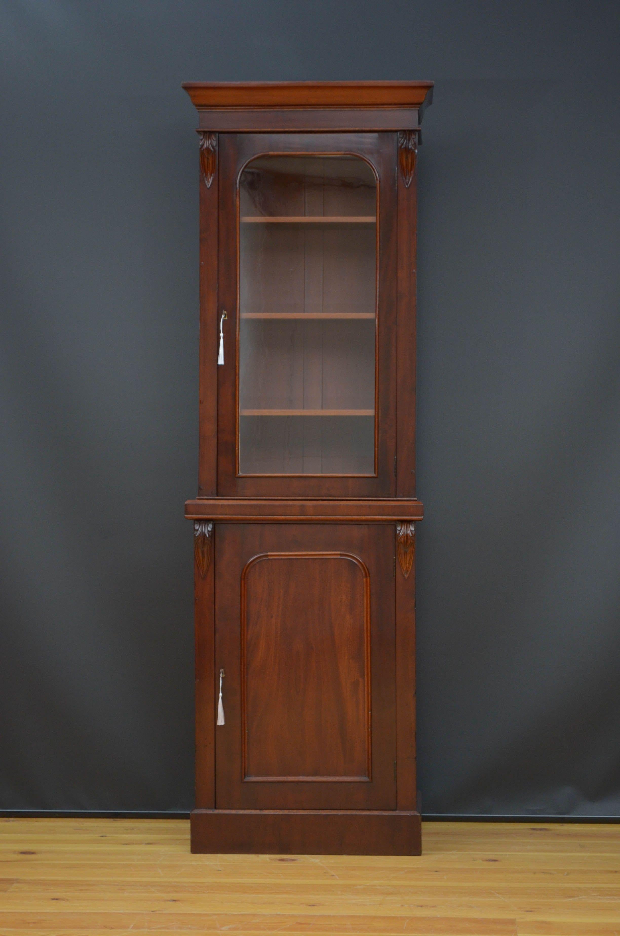 Sn5184 Slim Victorian bookcase in mahogany, having outswept cornice above a single glazed door fitted with original working lock and a key and enclosing three height adjustable shelves, all flanked by drop carvings. Projecting base having panelled