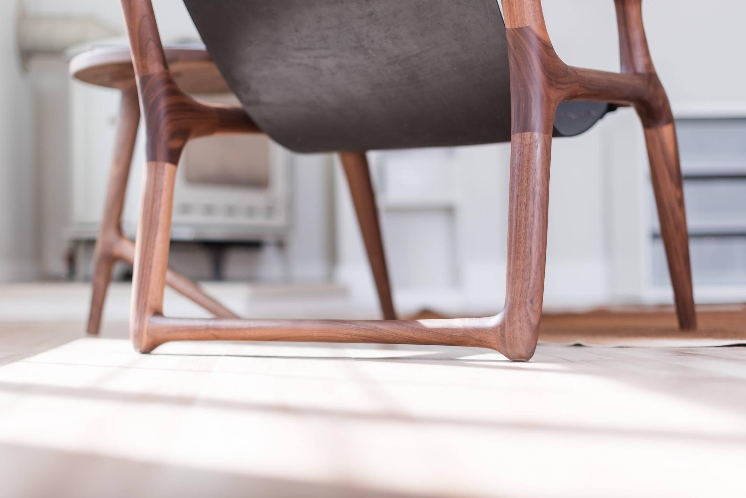 Cette pièce primée est la première chaise conçue par Fernweh Woodworking. Le cadre est façonné à la main à partir de noyer américain de haute qualité, offrant de riches tons bruns chauds avec une menuiserie élégante inspirée par le design danois,