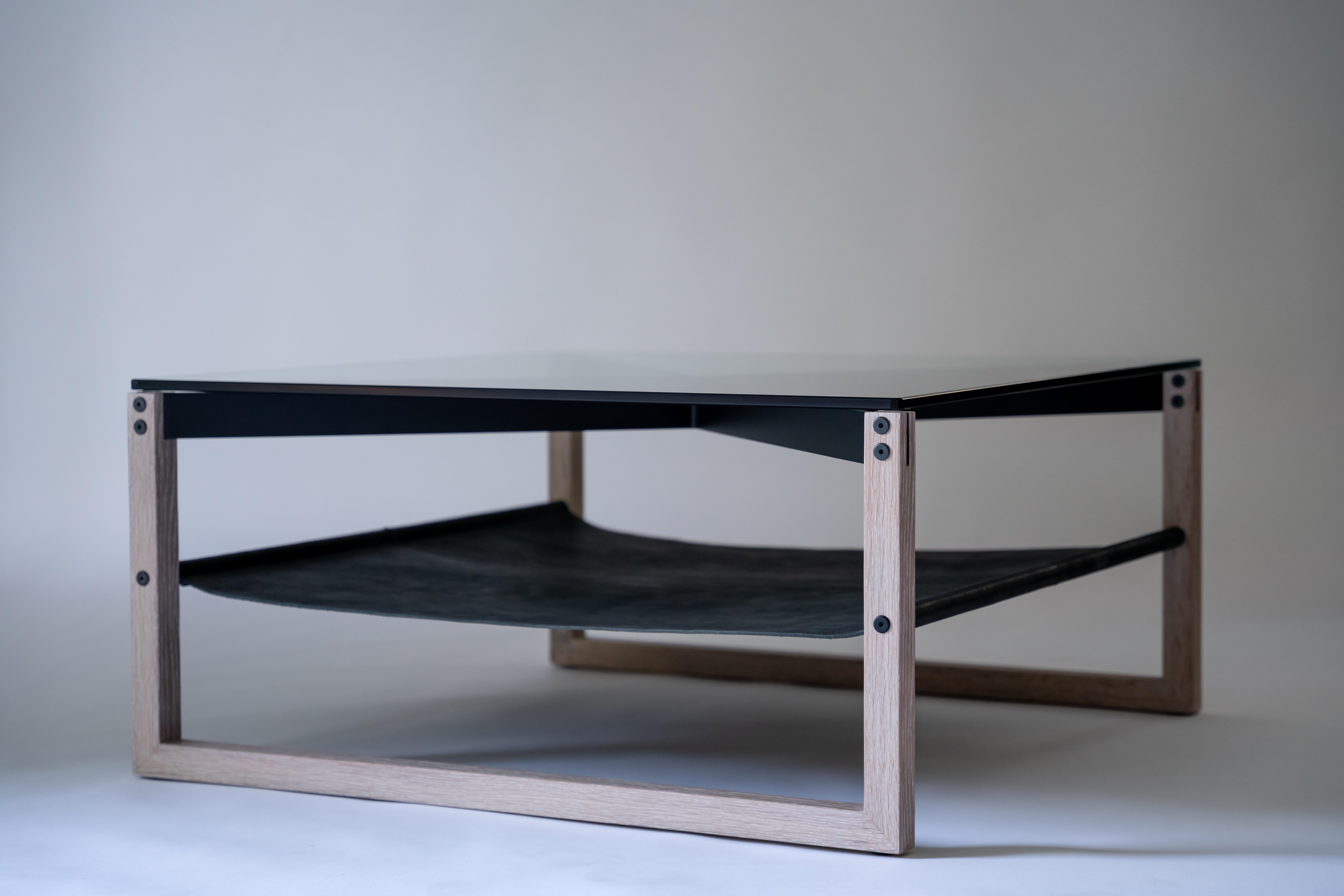 Mesa baja Sling - Roble blanco, cuero negro y cristal con estructura de aluminio recubierto de polvo negro

La mesa de centro Sling reúne cristal templado, roble blanco y cuero negro en una composición cuidadosamente equilibrada, elevada por una