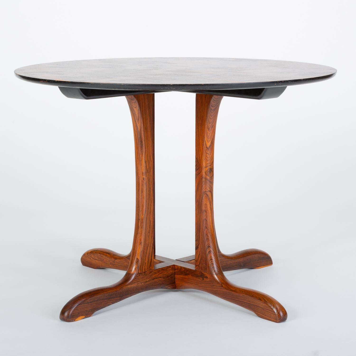 An F-12 dining table from Don Shoemaker’s Sling Collection, this round table makes an intriguing statement from any angle. The tabletop is supported by a deeply recessed cluster of four sculpted legs in cocobolo, a Mexican rosewood variety, with