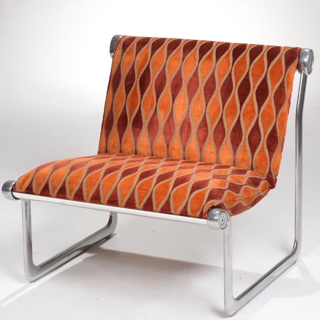 Sling lounge chair designed by Bruce Hannah and Andrew Morrison designed in 1971 for Knoll International. Sling seat upholstered in an orange biomorphic curve embossed velvet, on a polished aluminum frame.
    