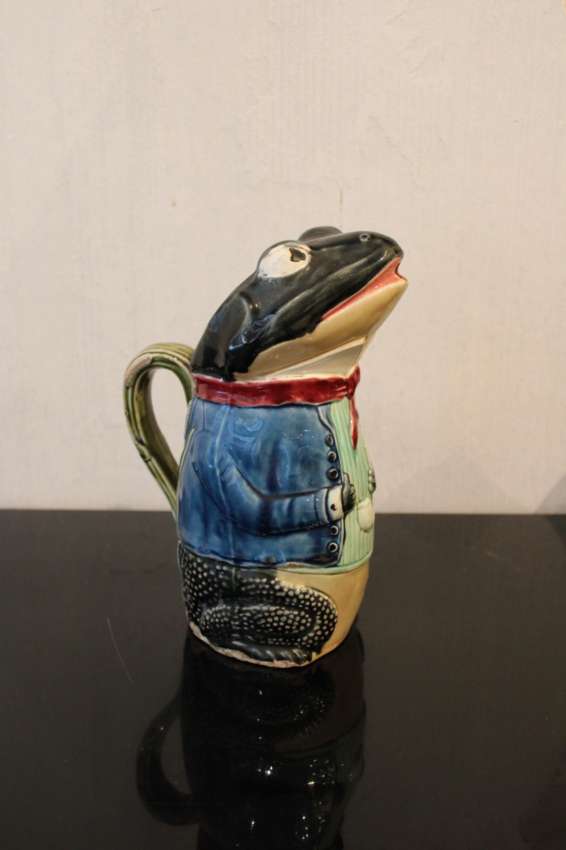 Slip pitcher, represents a frog in suit. 
Signed under the base. 
France, early 20th century

Little chips at the bottom of the suit, above the right leg. 

