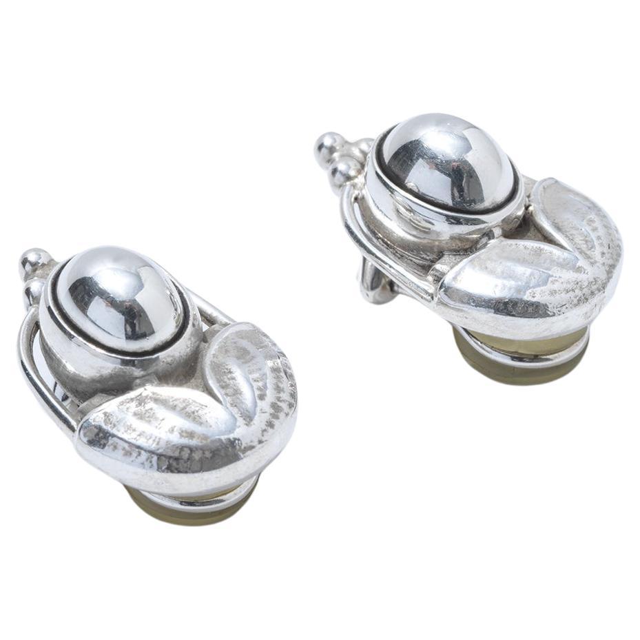 Diese Ohrringe sind aus Silber gefertigt und verfügen über ein poliertes, kugelförmiges Mittelstück, das das Licht wunderschön reflektiert. Um die zentrale Kugel herum ist das Silber in komplizierte, organische Formen geformt, die an Blätter oder