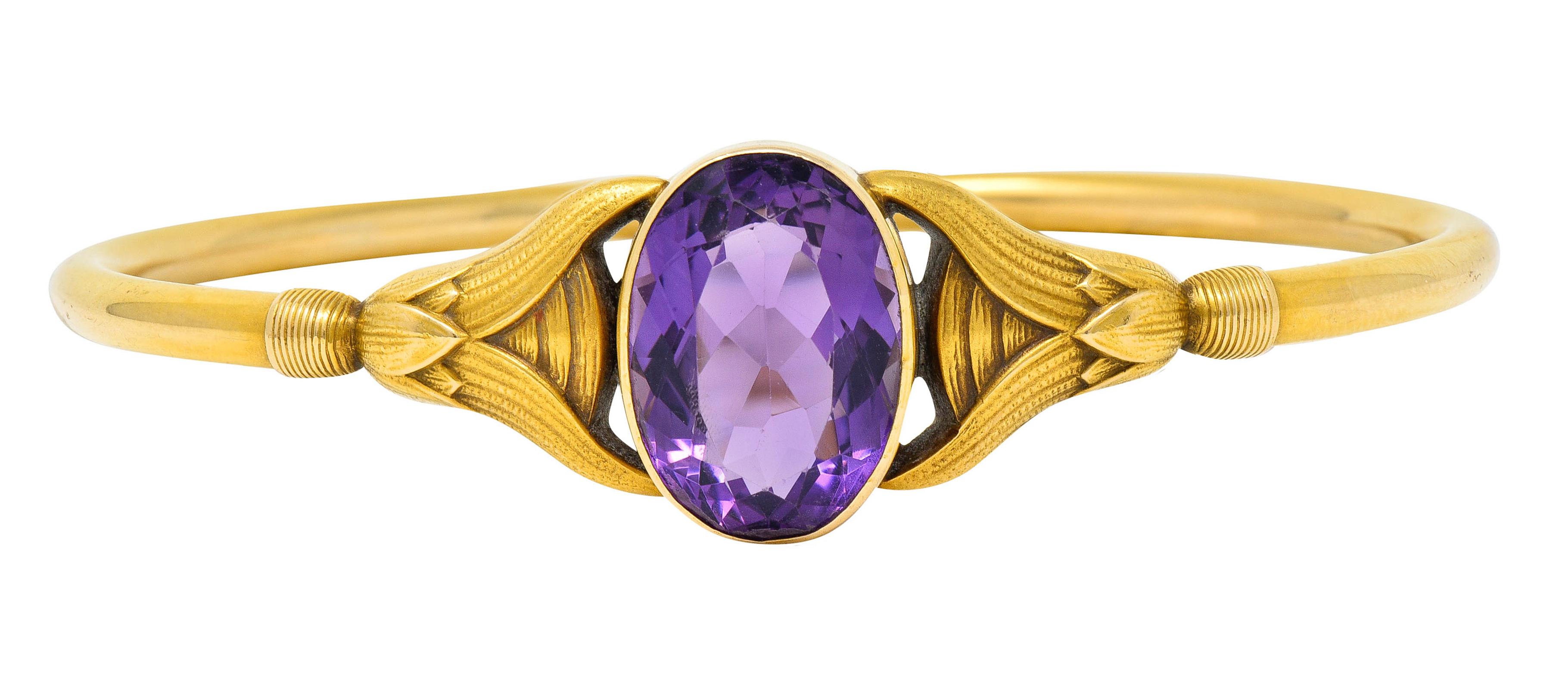 Centering an oval cut amethyst measuring approximately 17.5 x 12.0 mm

Bezel set while exhibiting strong and uniform purple color

Completed by stylized lotus shoulders

Stamped 14 for 14 karat gold

Maker's mark for Sloan & Co.

Circa: 1900

Inner
