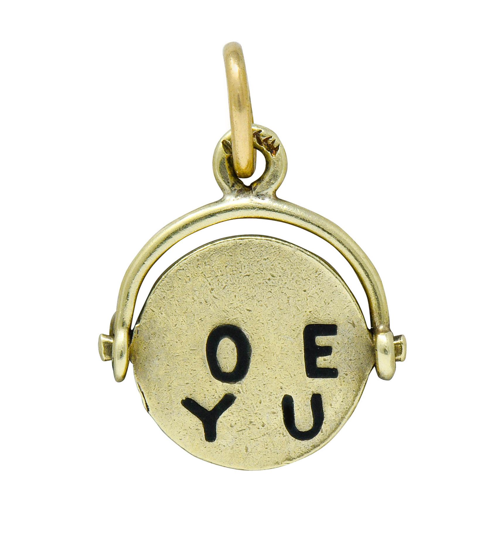Charm is designed as a thaumatrope illusion with a rotating circular center

With black enamel letters the spell out 'I Love You' when spun

Maker's mark for Sloan & Co.

Stamped 14K for 14 karat gold

Circa: 1940s

Measures: 7/16 x 5/8 inch