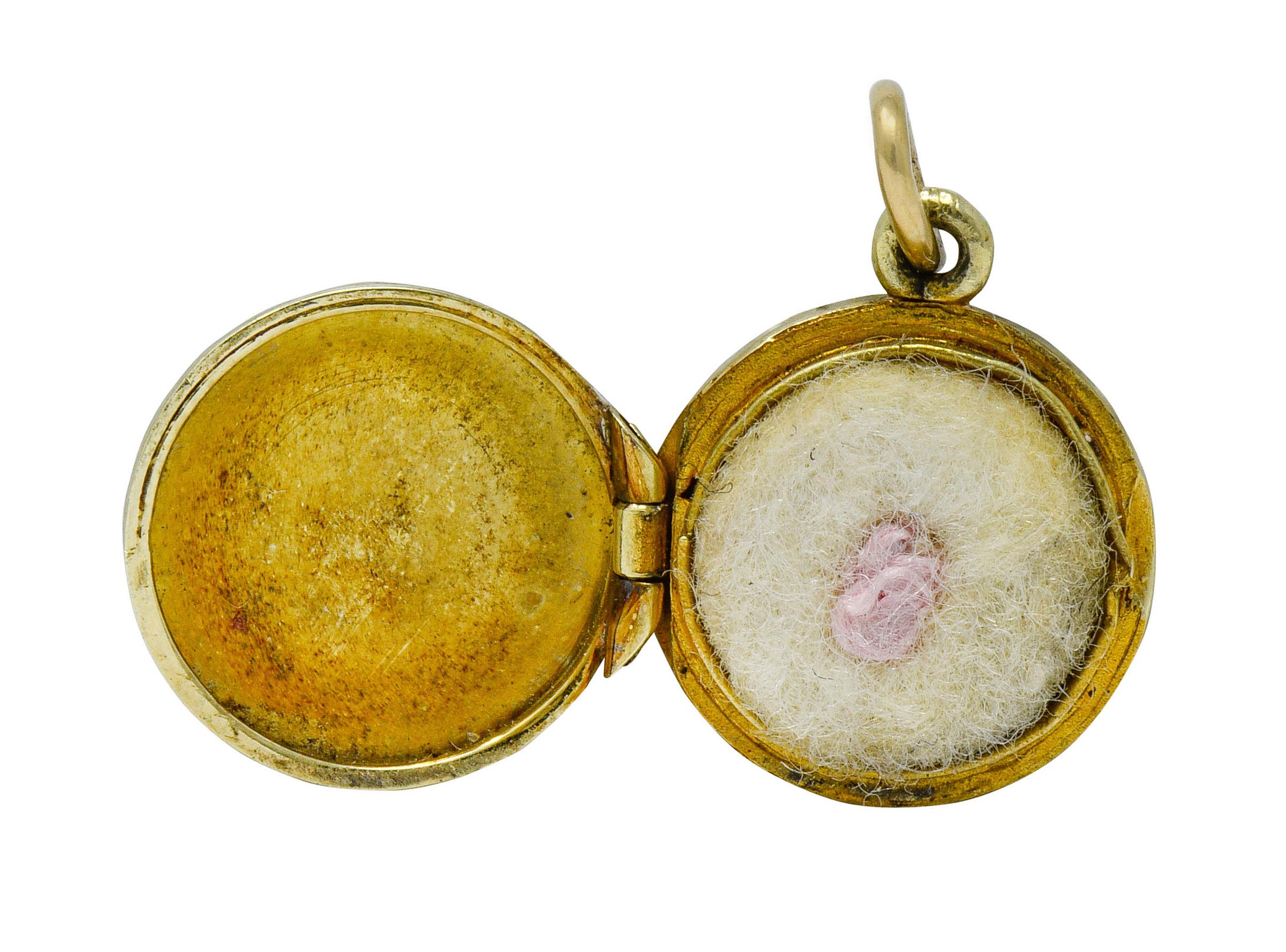 Circular charm featuring a deeply engraved radiating motif on both back and front

Opens on a hinge to reveal a removable powder puff with a cute pink pom pom

Completed by a jump ring bale

Maker's mark for Sloan & Co.

Stamped 14K for 14 karat