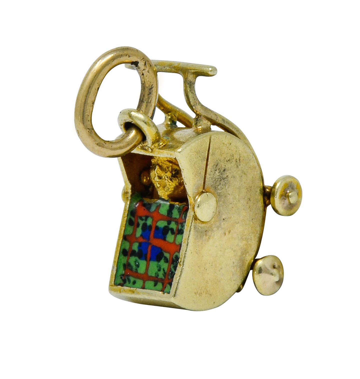Designed as a pram baby carriage with a highly rendered baby inside

Covered by a colorful plaid blanket comprised of glossy enamel exhibiting very minor loss

Completed by jump ring

Maker's mark for Sloan & Co.

Stamped 14K for 14 karat