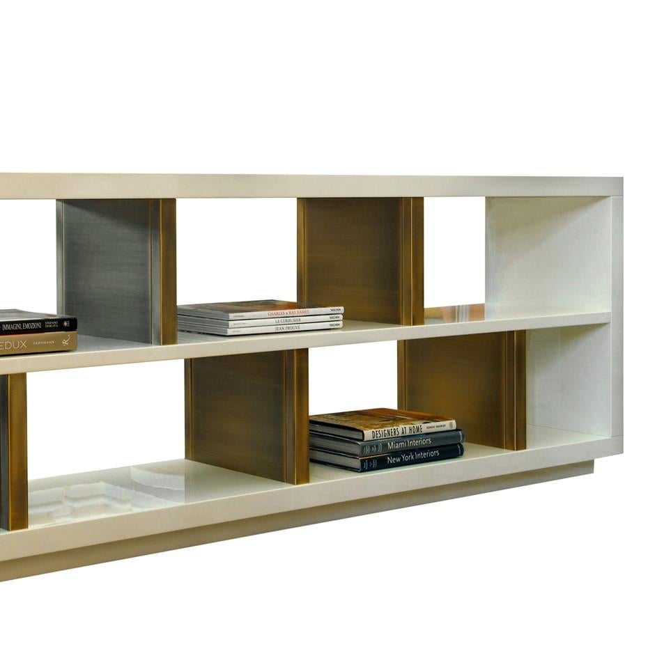 Part of the sophisticated and unique Sloane collection, this bookcase is elegant and modern and will be stunning by a wall, behind a sofa, or in the centre of a room. Its structure rests on a plinth base and is made of wood with a refined glossy