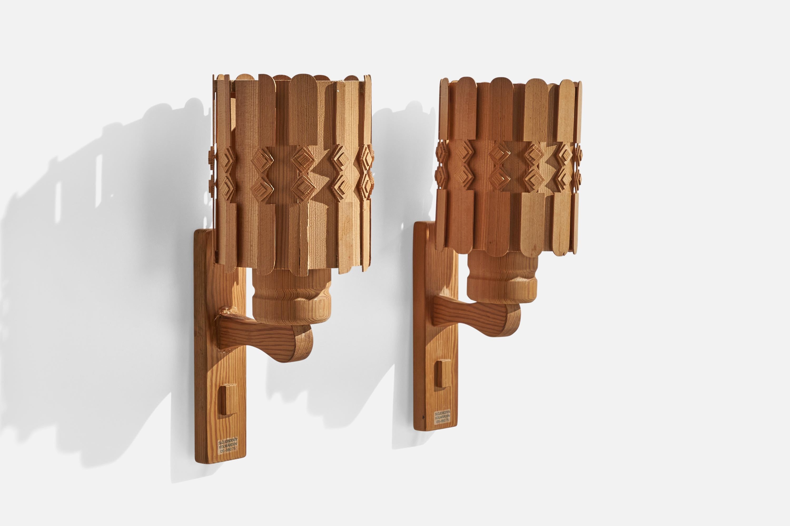 A pair of pine and pine veneer wall lights designed and produced by Slöjdboden Kolmården, Sweden, 1970s.

Overall Dimensions (inches): 13” H x 5.25” W x 6.25” D
Back Plate Dimensions (inches): 7.75” H x 2” W x .75” D
Bulb Specifications: E-26