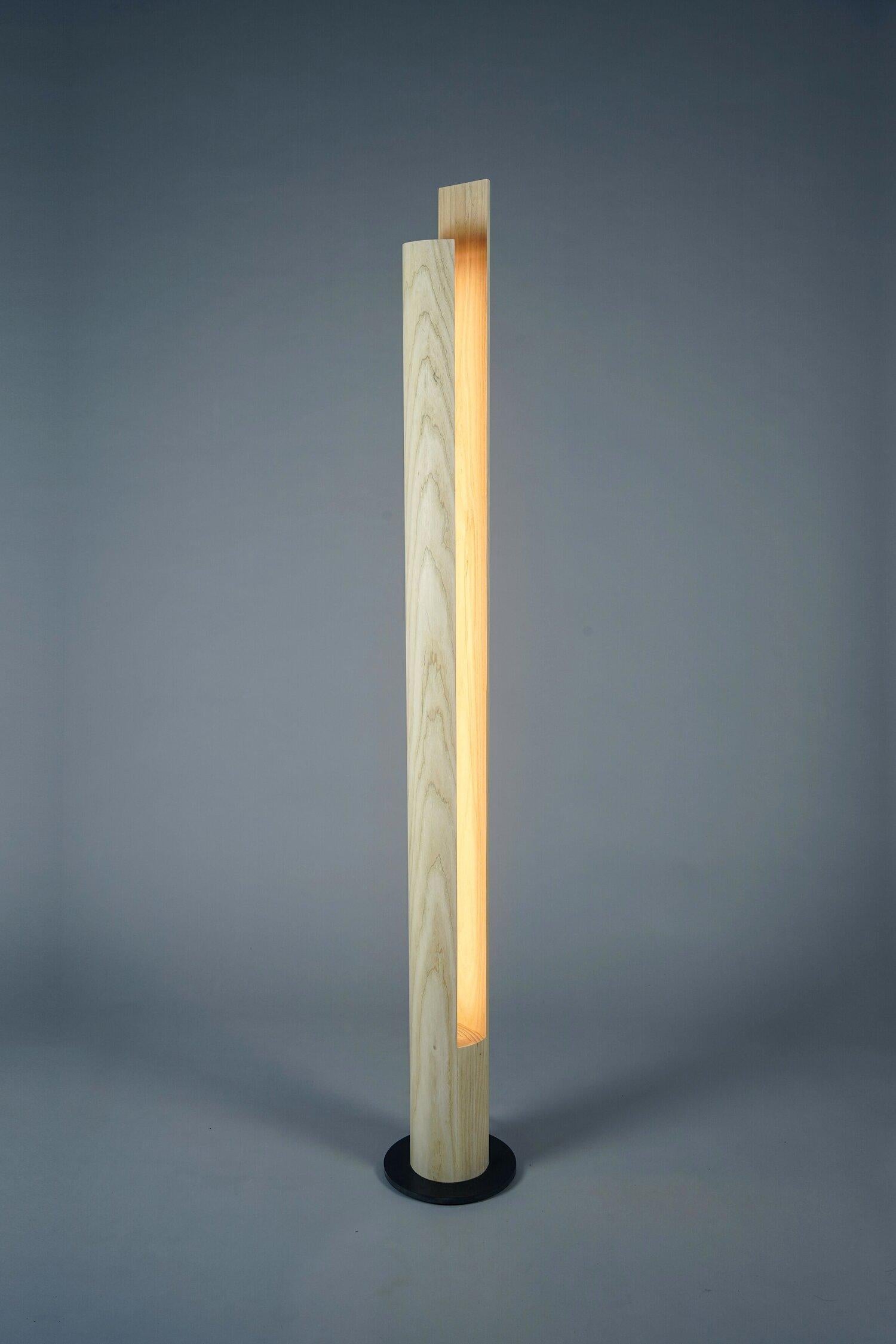 Lampada da terra a colonna in legno di frassino e base in acciaio. Un elemento di illuminazione a LED dimmerabile è posizionato a filo del foro e ha una durata di 50.000 ore. Un interruttore ON/OFF con dimmer a pavimento permette ai LED di