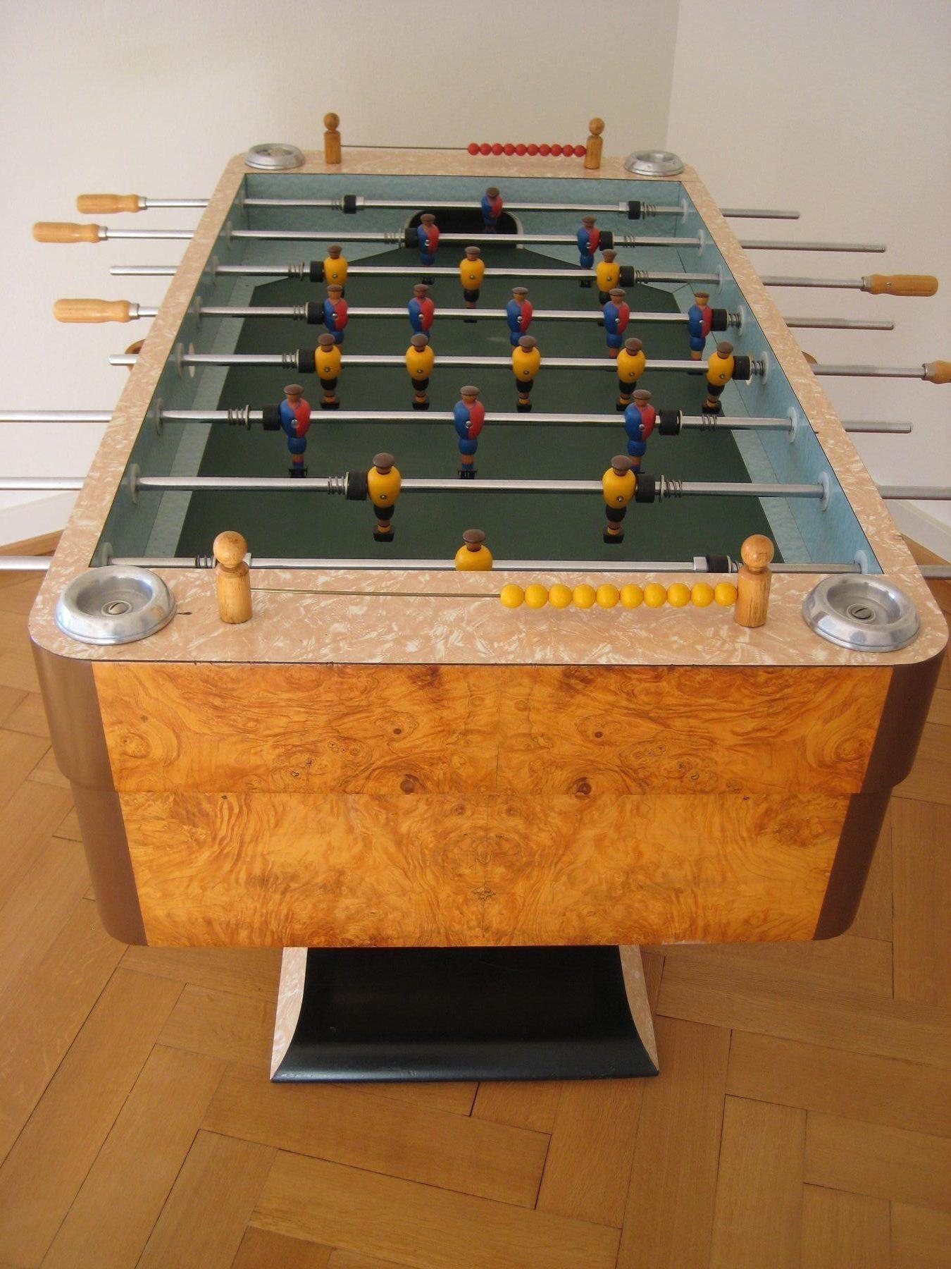 Art Deco football table

Very rare and well preserved toggle box presumably 1940s-1950s. Brand Sporlux (Geneva). Beautiful burl wood veneer, sand-blasted glass top, wooden player hand painted with original jerseys of FCB and YB. 20 centimes
