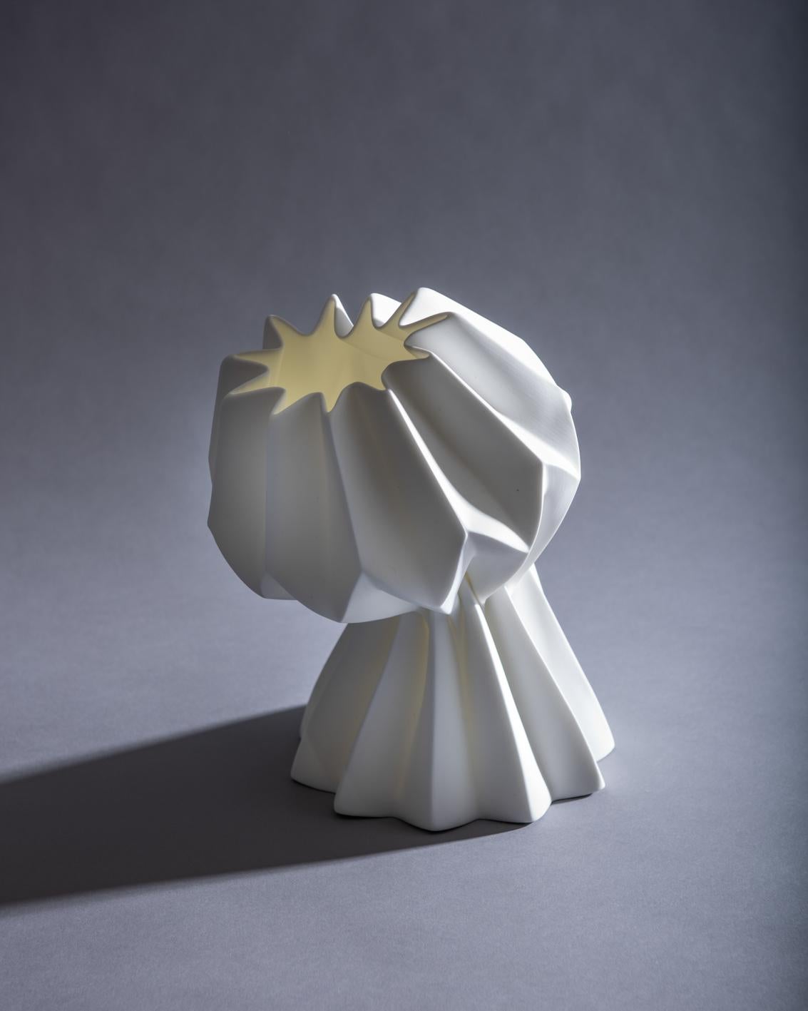 Slump vase – half slump variation – capturing ideas of form, structure and failure; the pleated paper form is translated into a fine bone china that is stressed through the excessive heat of the furnace into a poetic collapse. Developed in the